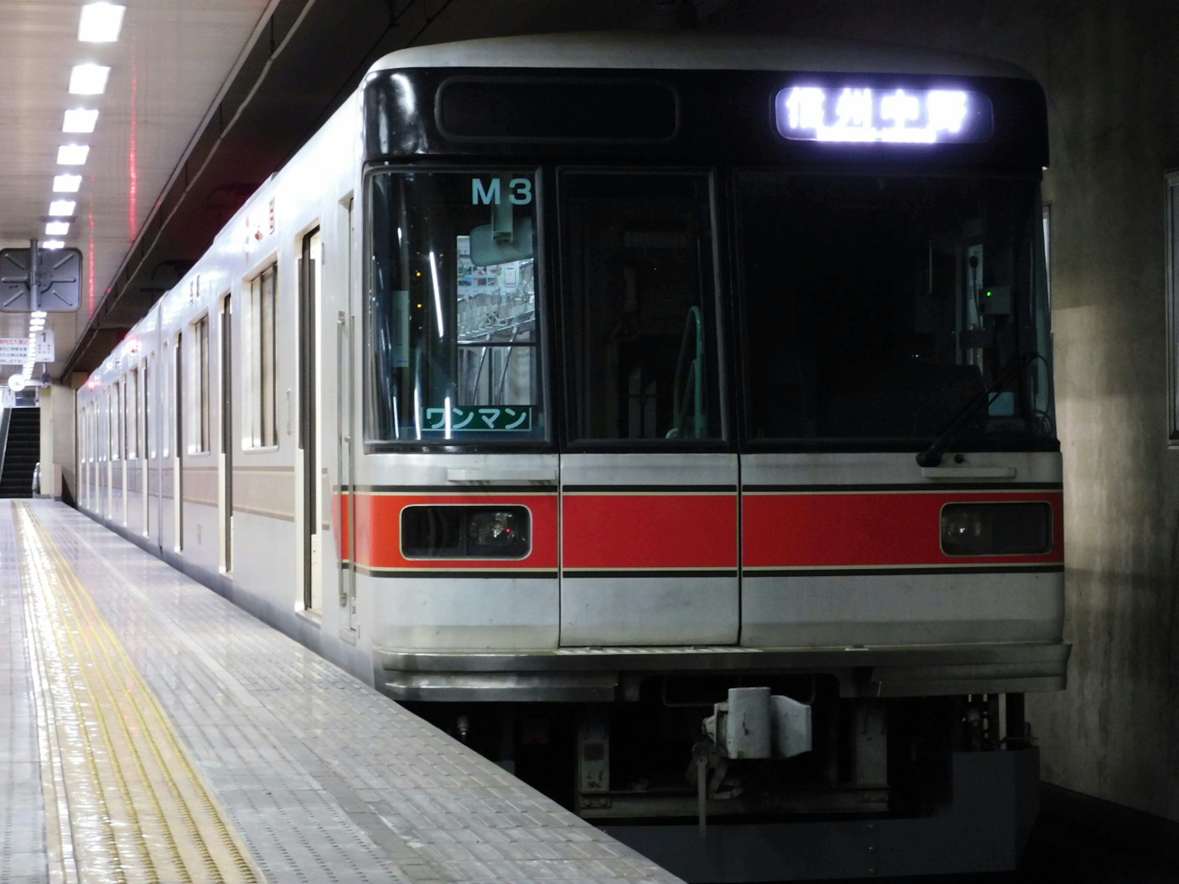 地下鉄の電車が駅に停車中 赤いストライプが特徴