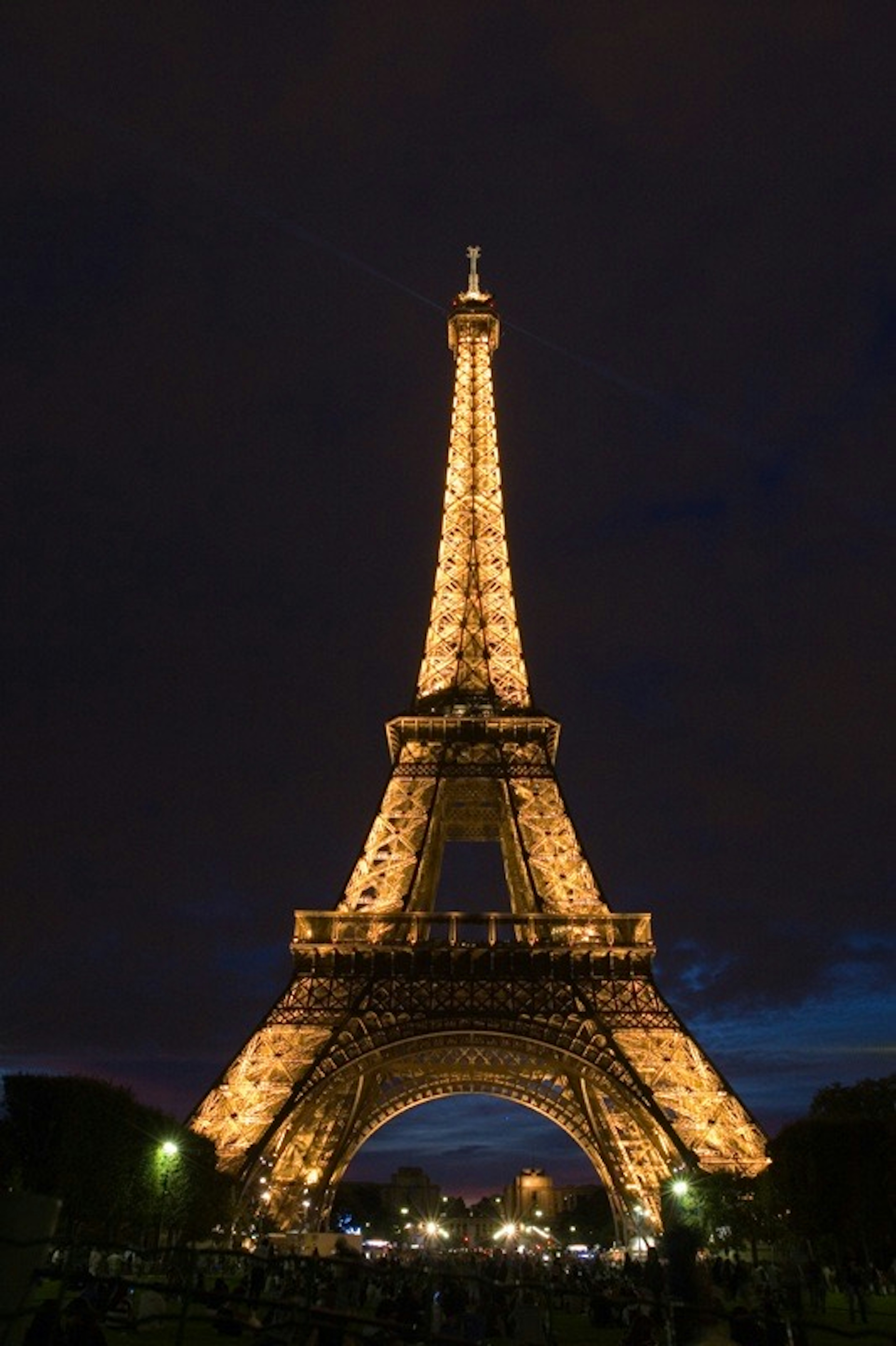 Menara Eiffel diterangi di malam hari dengan langit gelap