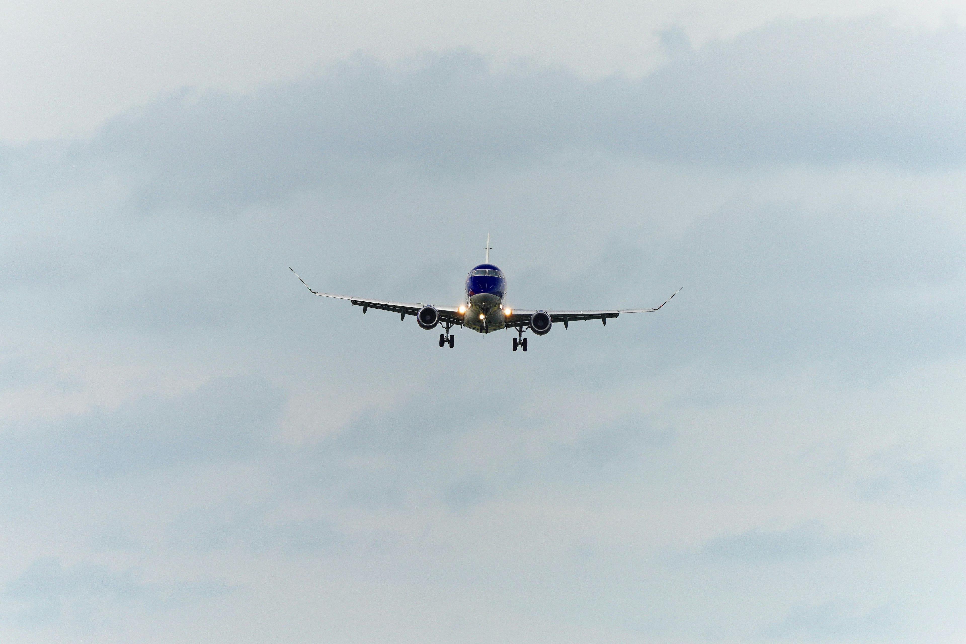 Avión aterrizando contra un fondo de cielo nublado