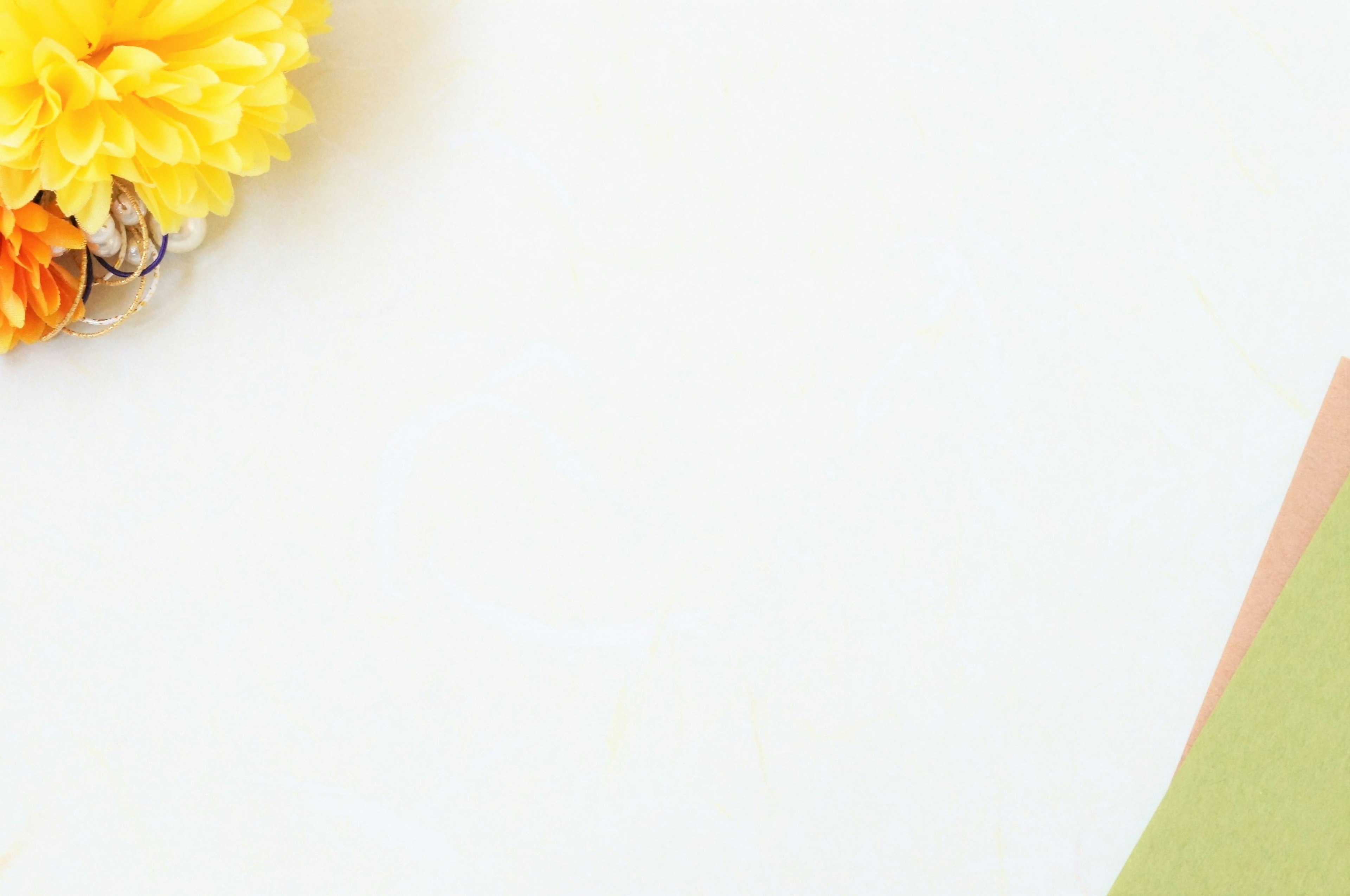 Yellow flower on a white background with green and pink paper