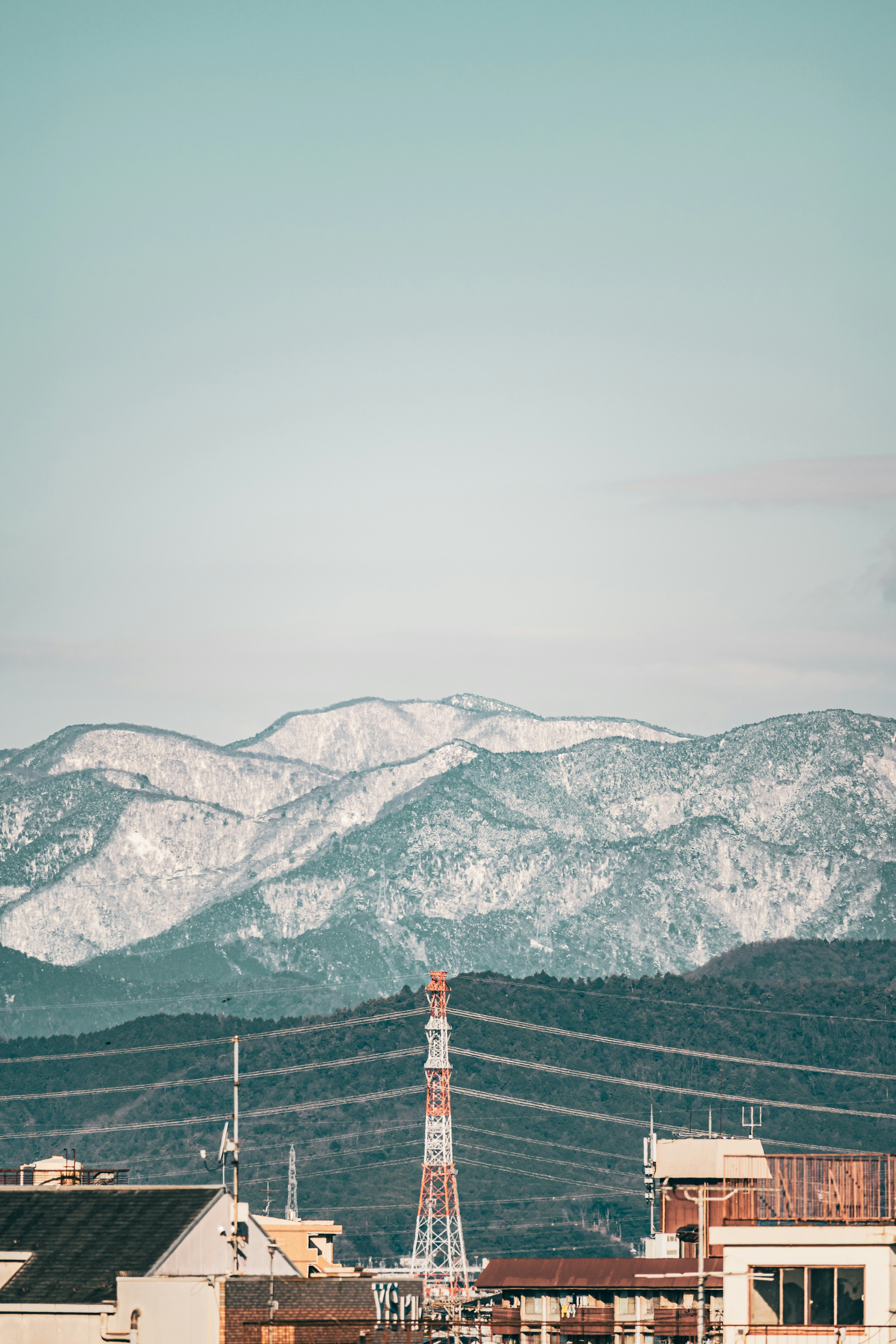 雪をかぶった山々とその前景にある都市の風景