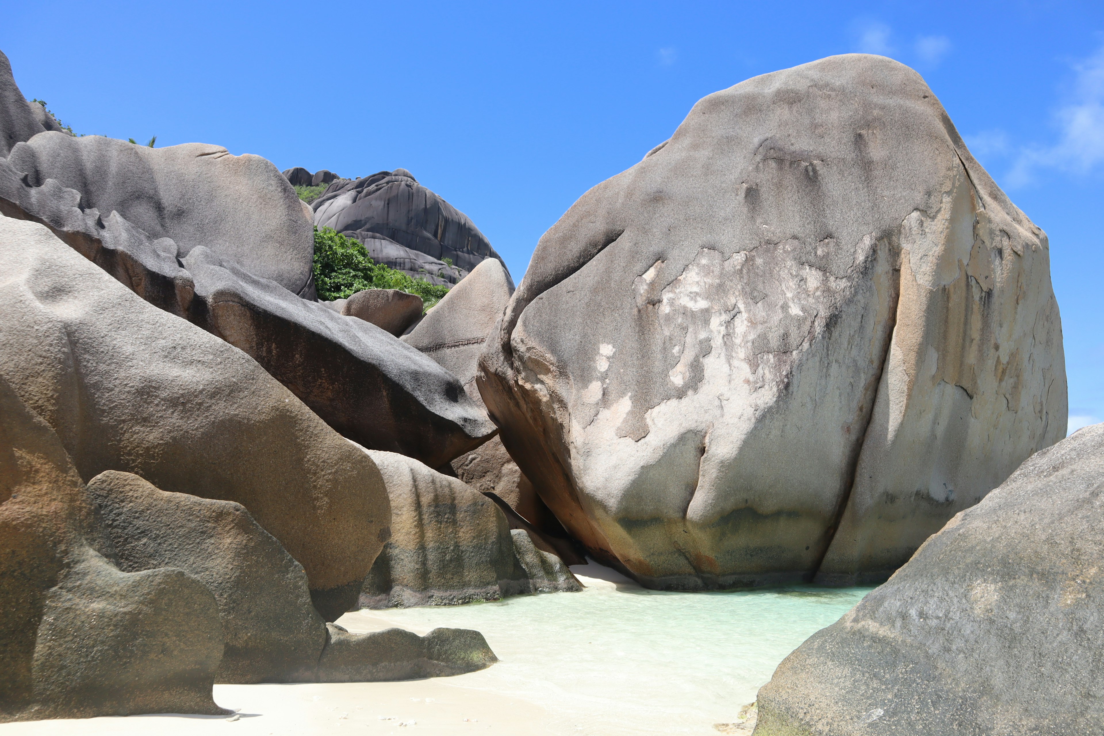 Large boulders on a beautiful beach with clear turquoise water