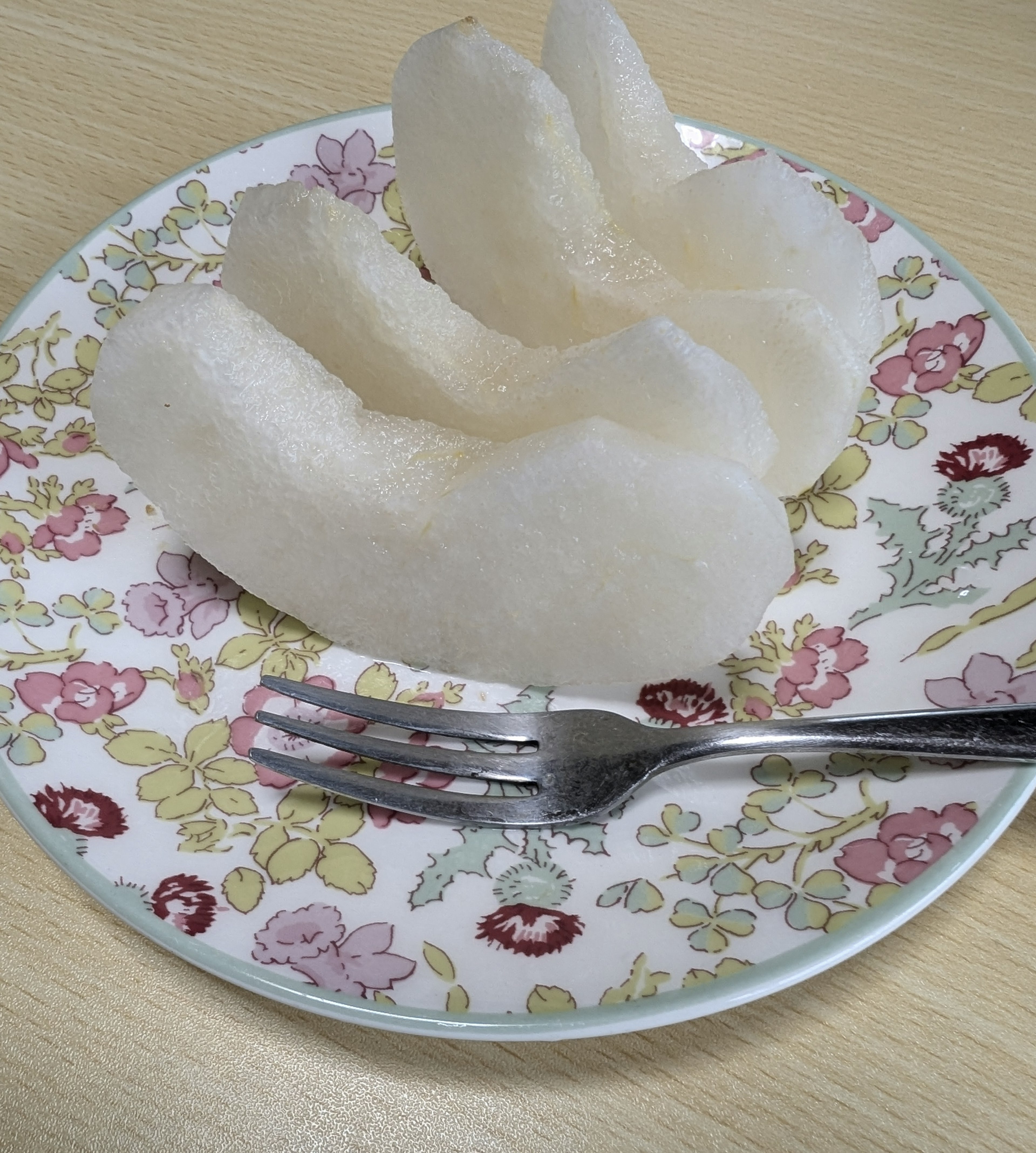 Slices of white fruit served on a floral patterned plate