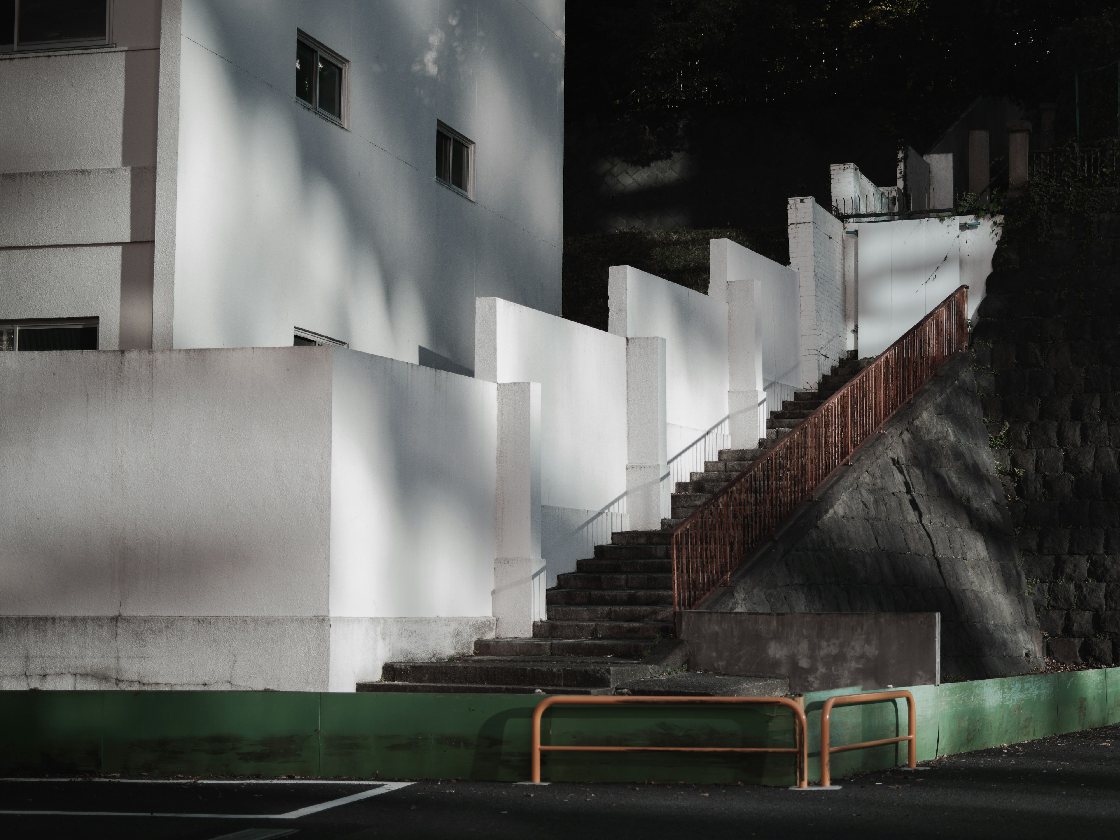 Vue extérieure d'un bâtiment avec des murs blancs et des escaliers