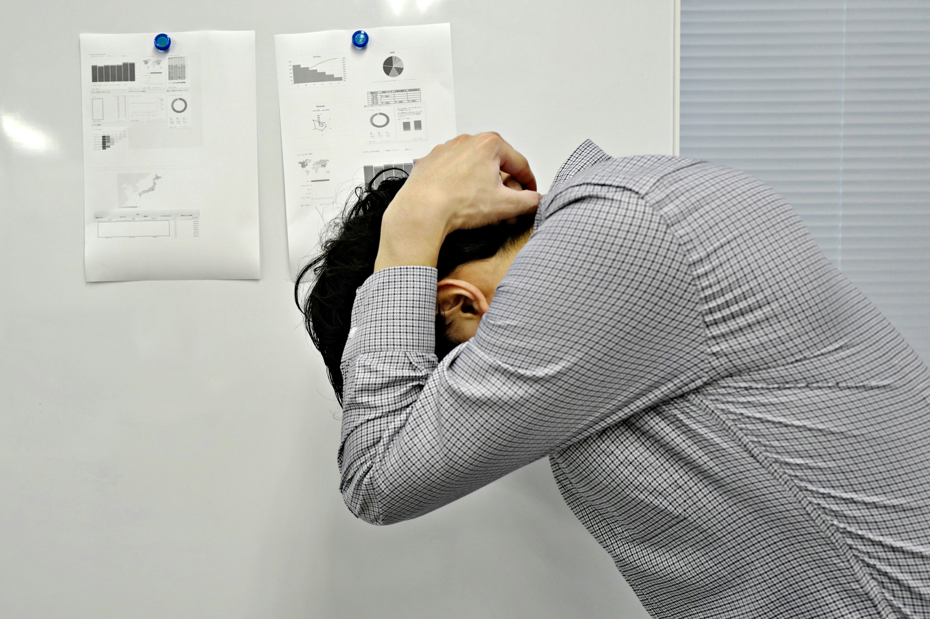 A stressed man holding his head in despair