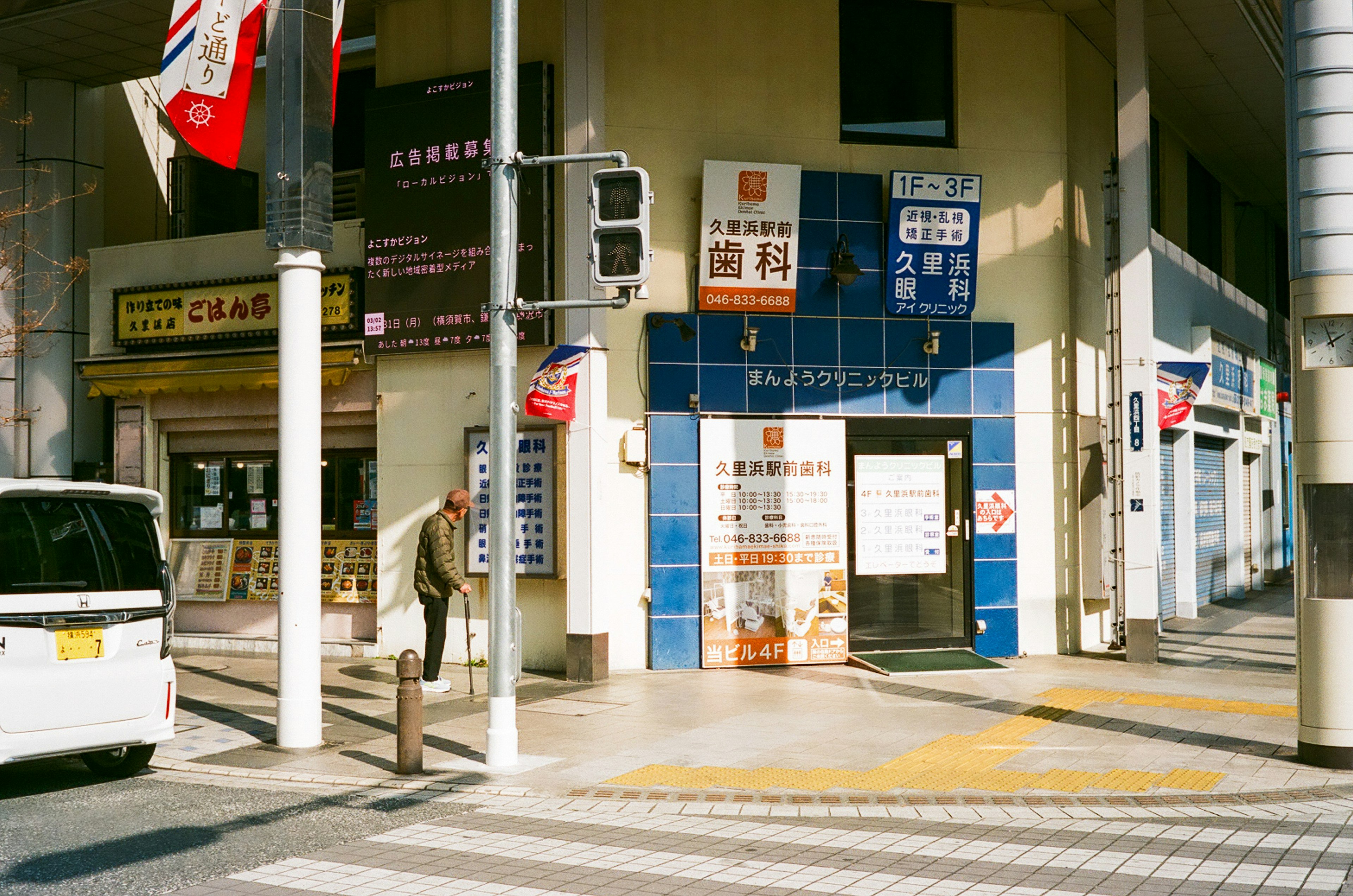 街角有一家蓝白瓷砖外墙的餐厅和一个行走的人