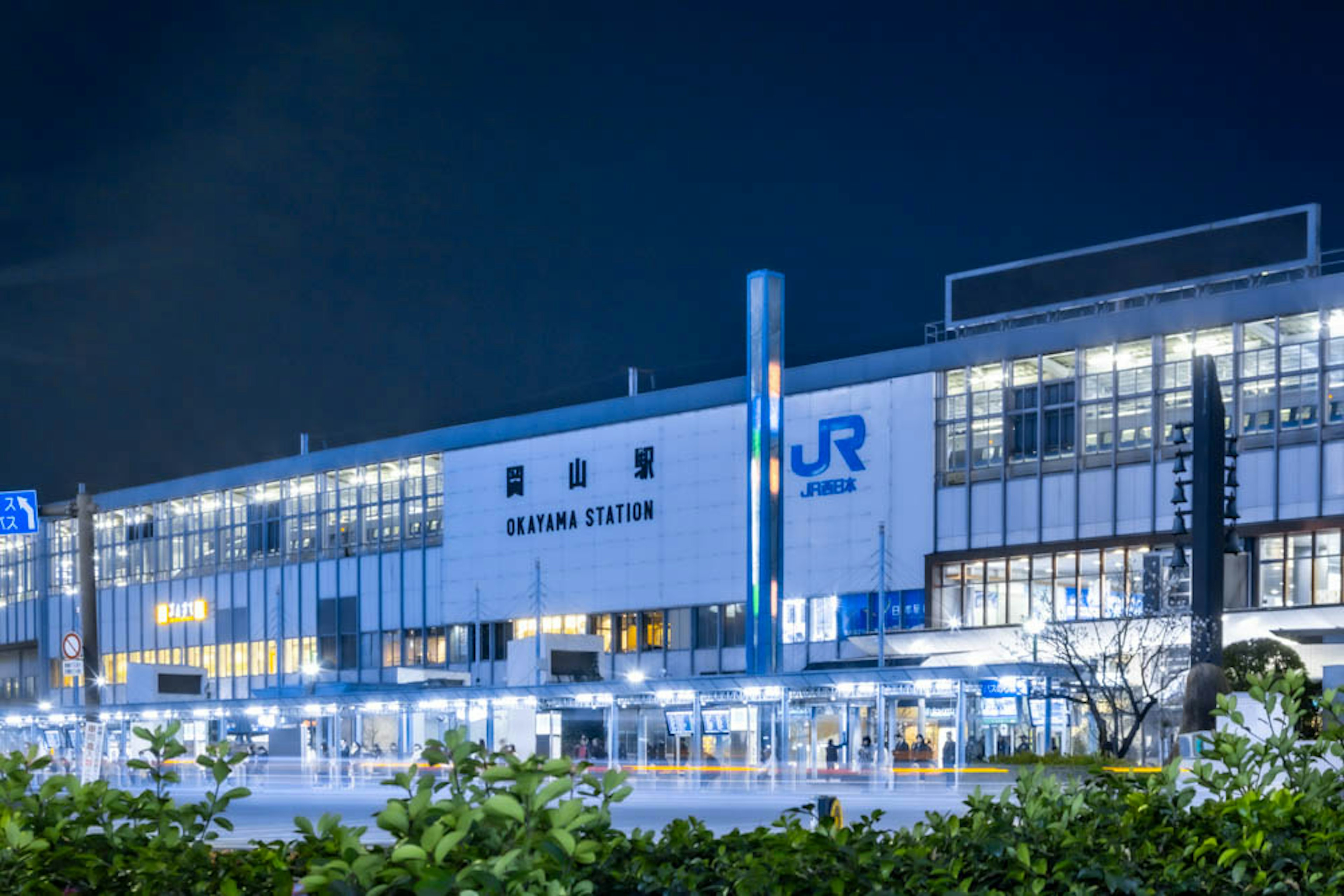 Außenansicht des Takasaki Bahnhofs bei Nacht mit beleuchtetem Stationsnamen