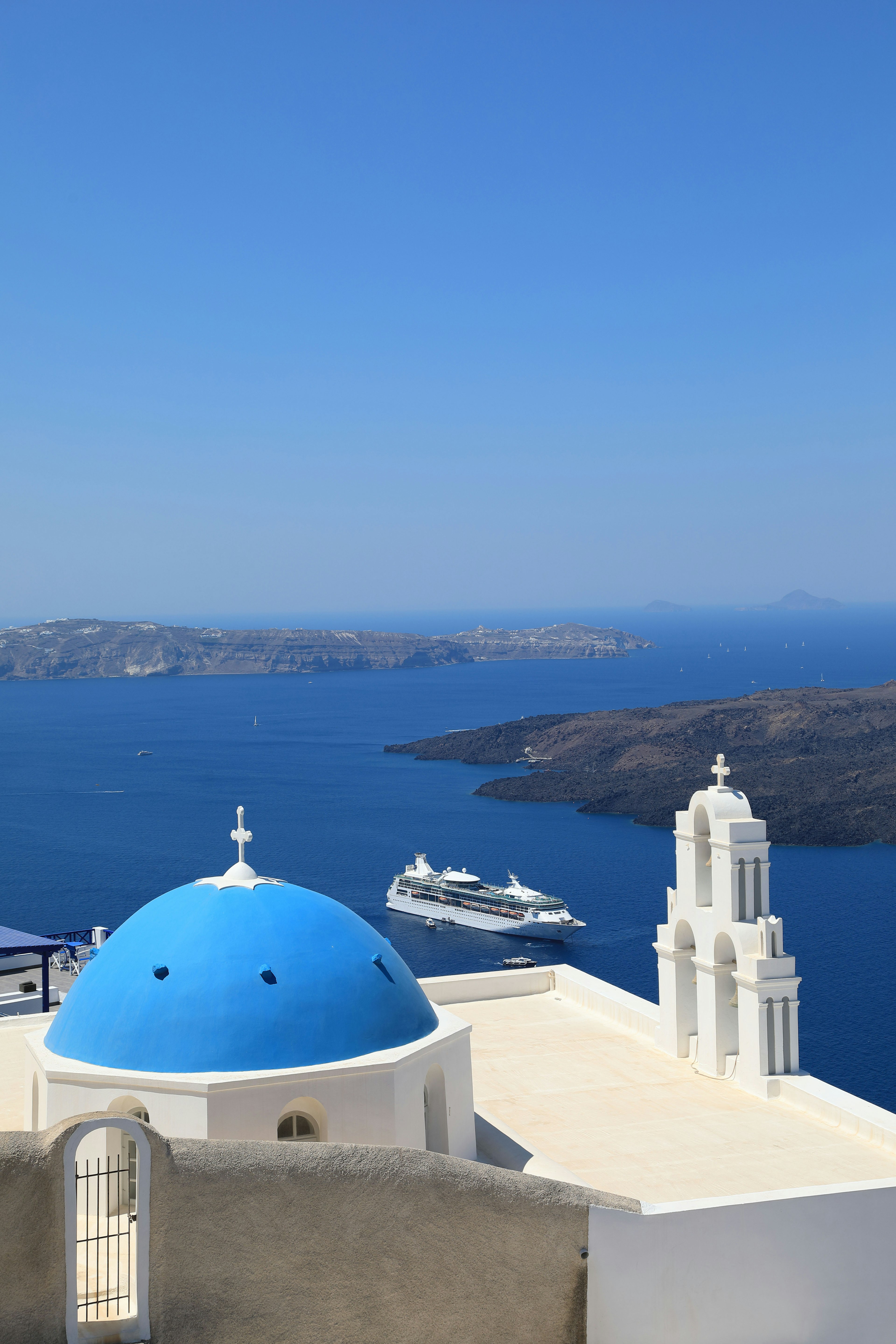 Blick auf die Insel Santorin mit einer blauen Kuppel und weißen Gebäuden über dem Meer