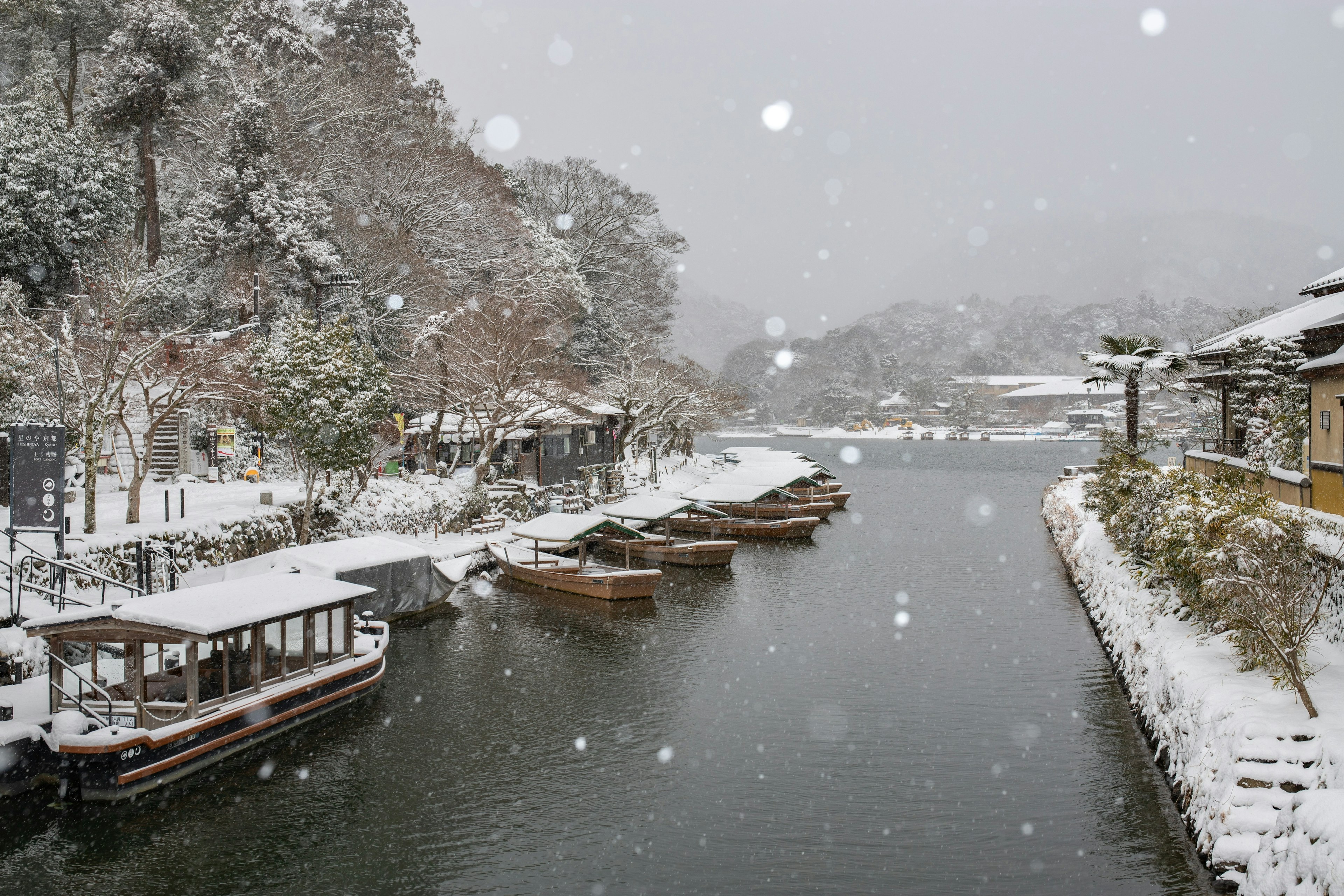 Snow-covered river with traditional boats lined up