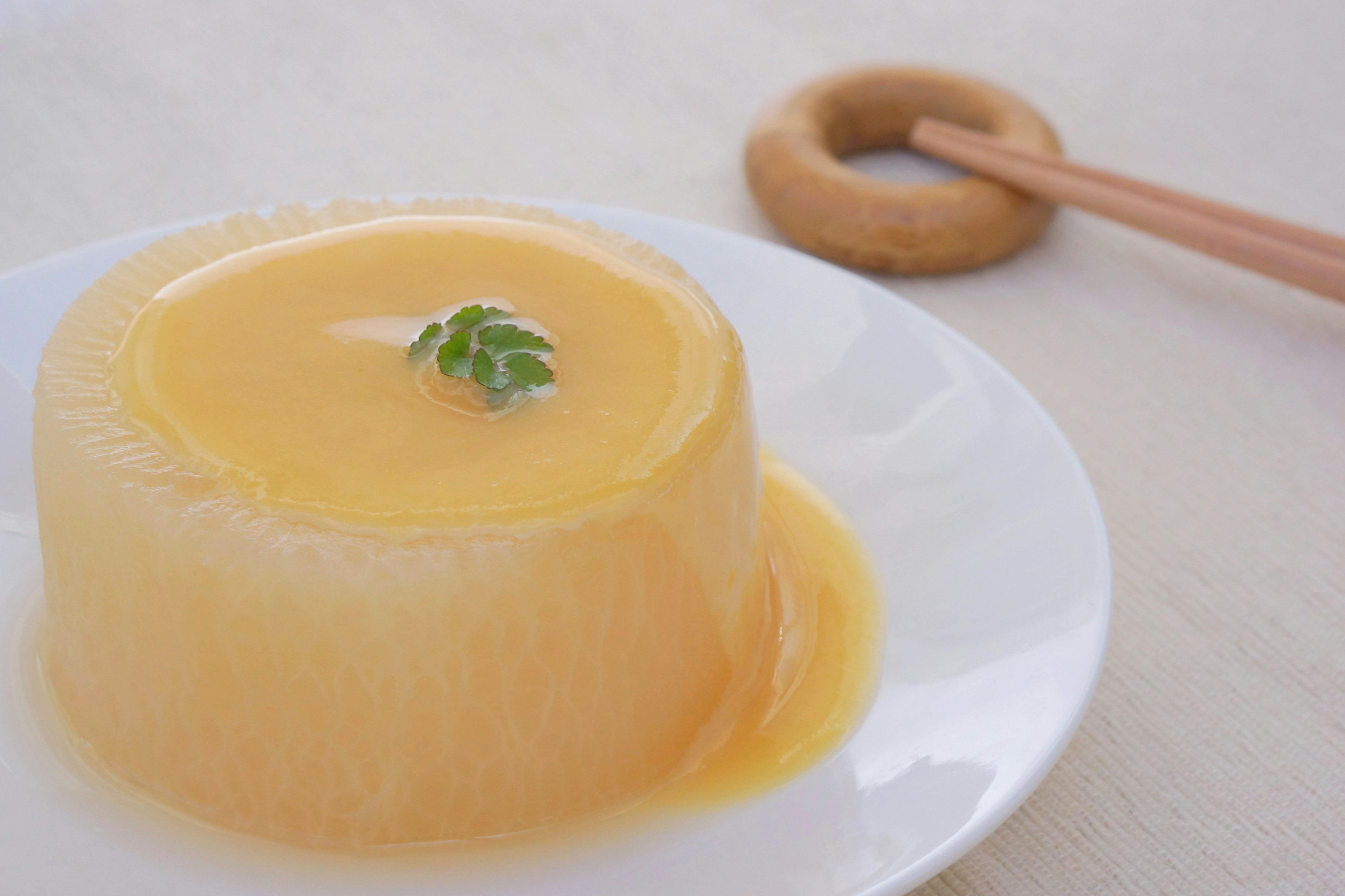 Dessert en gelée jaune clair garni d'une feuille de menthe