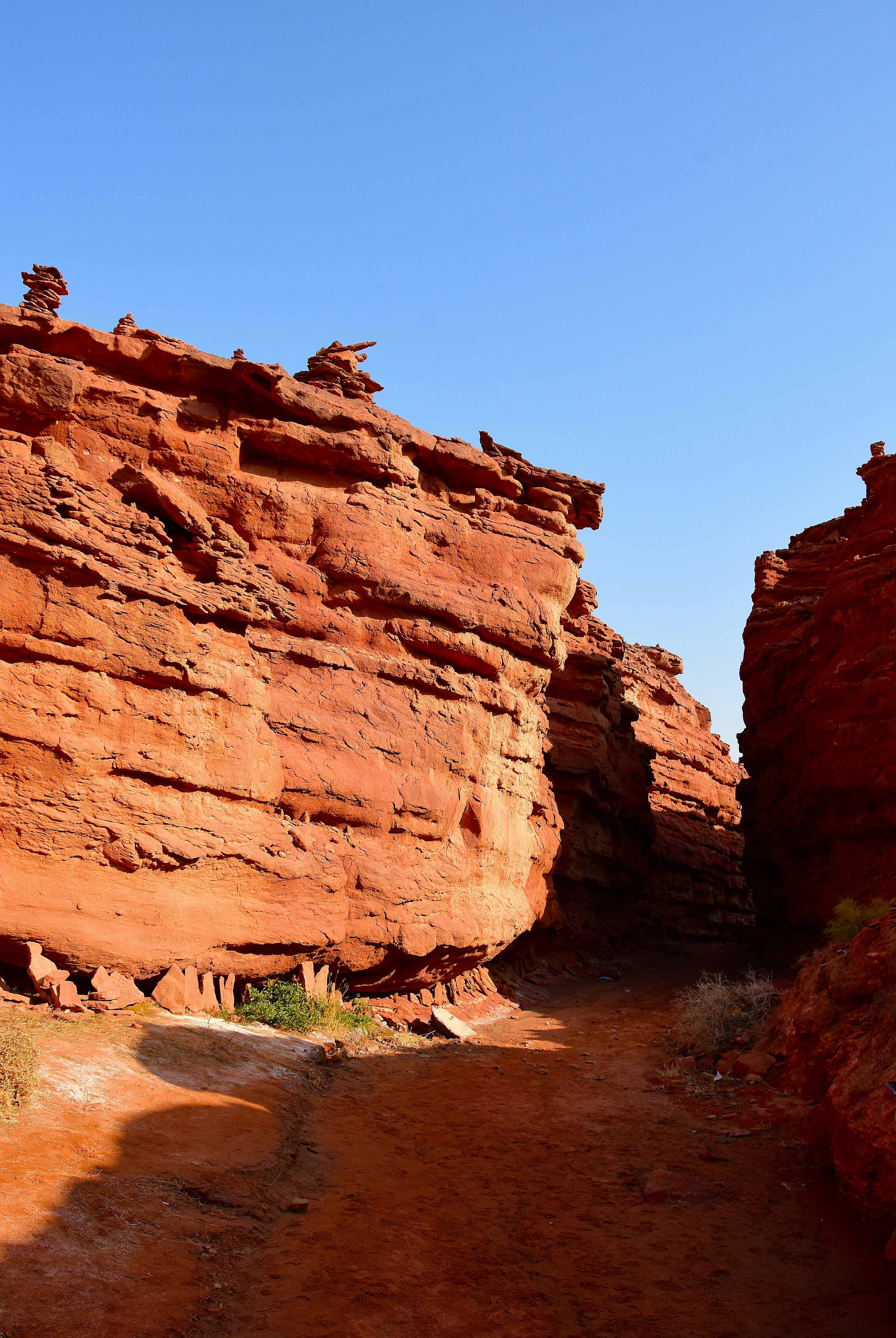 Un camino estrecho que serpentea entre muros de cañón de roca roja