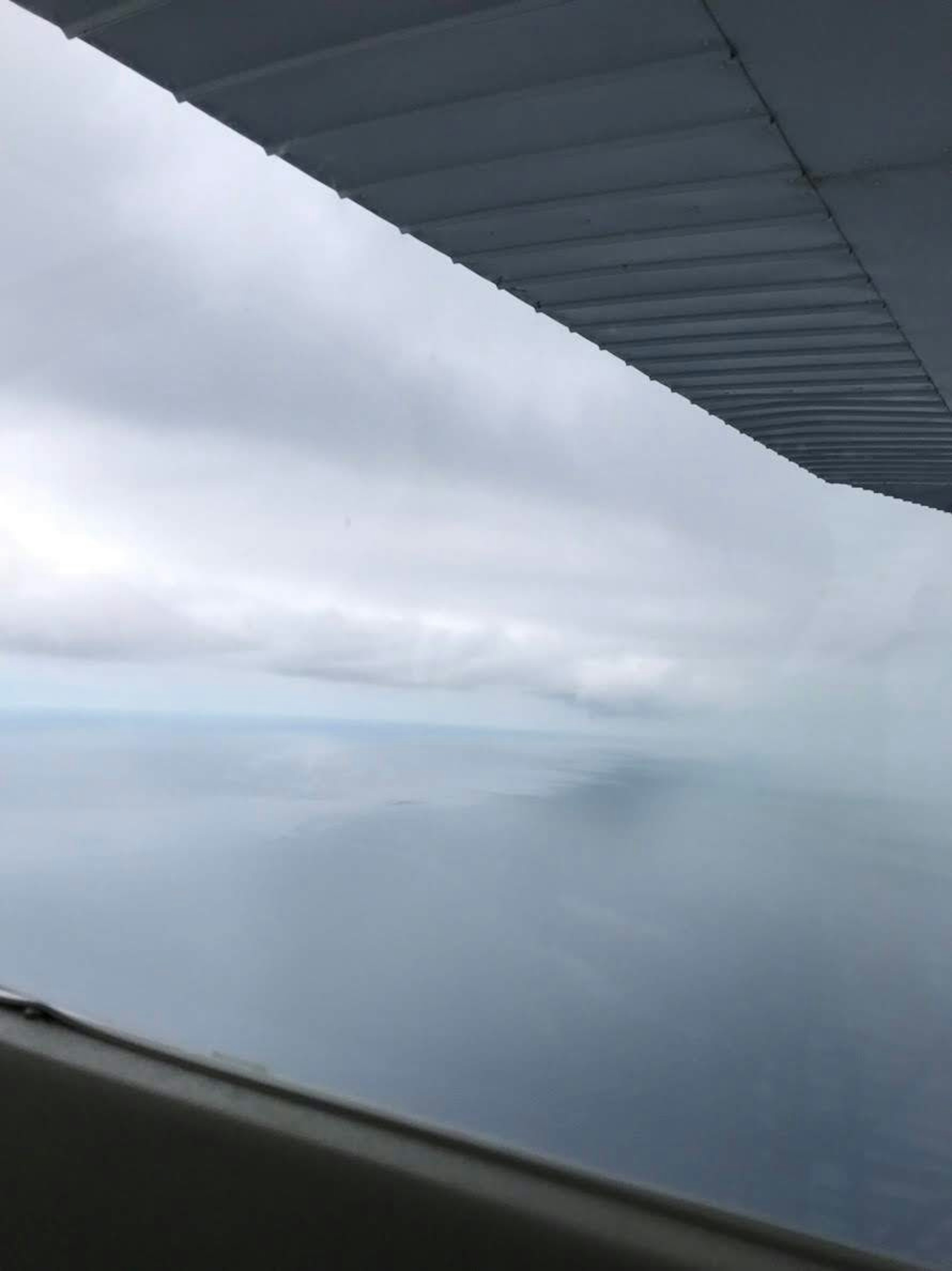 Vista dell'oceano nuvoloso con una parte dell'ala di un aereo