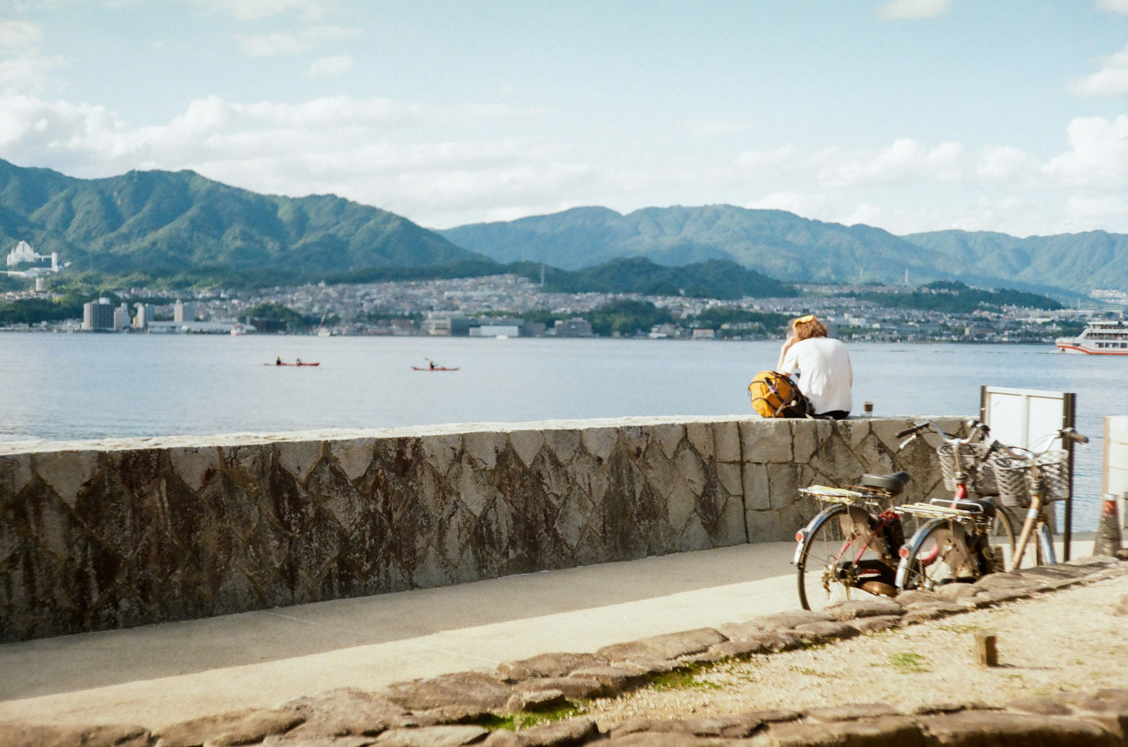 Un hombre mirando al mar tranquilo con una bicicleta cerca