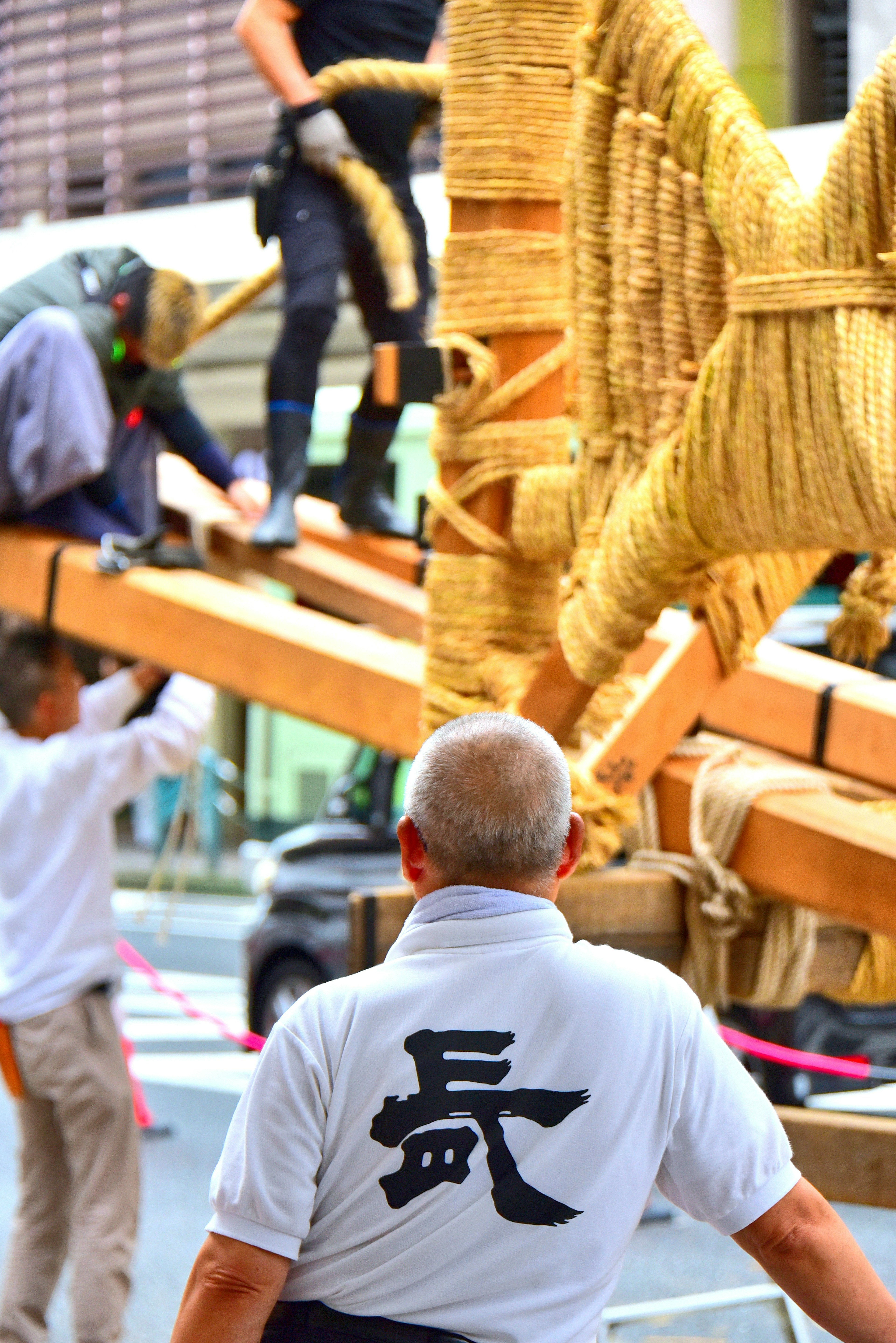 Orang-orang sedang mempersiapkan festival dengan struktur kayu