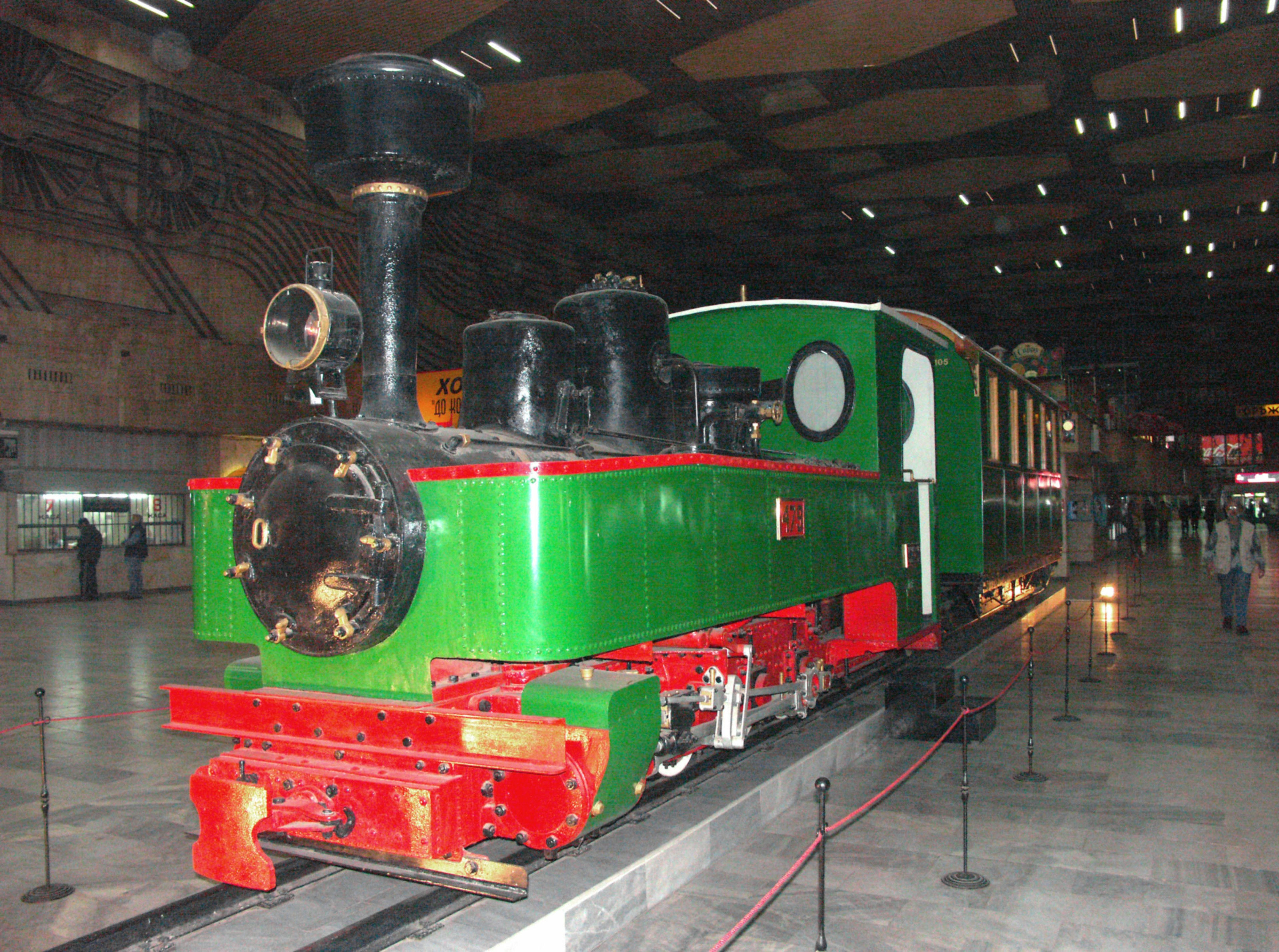 Green steam locomotive displayed on a station platform