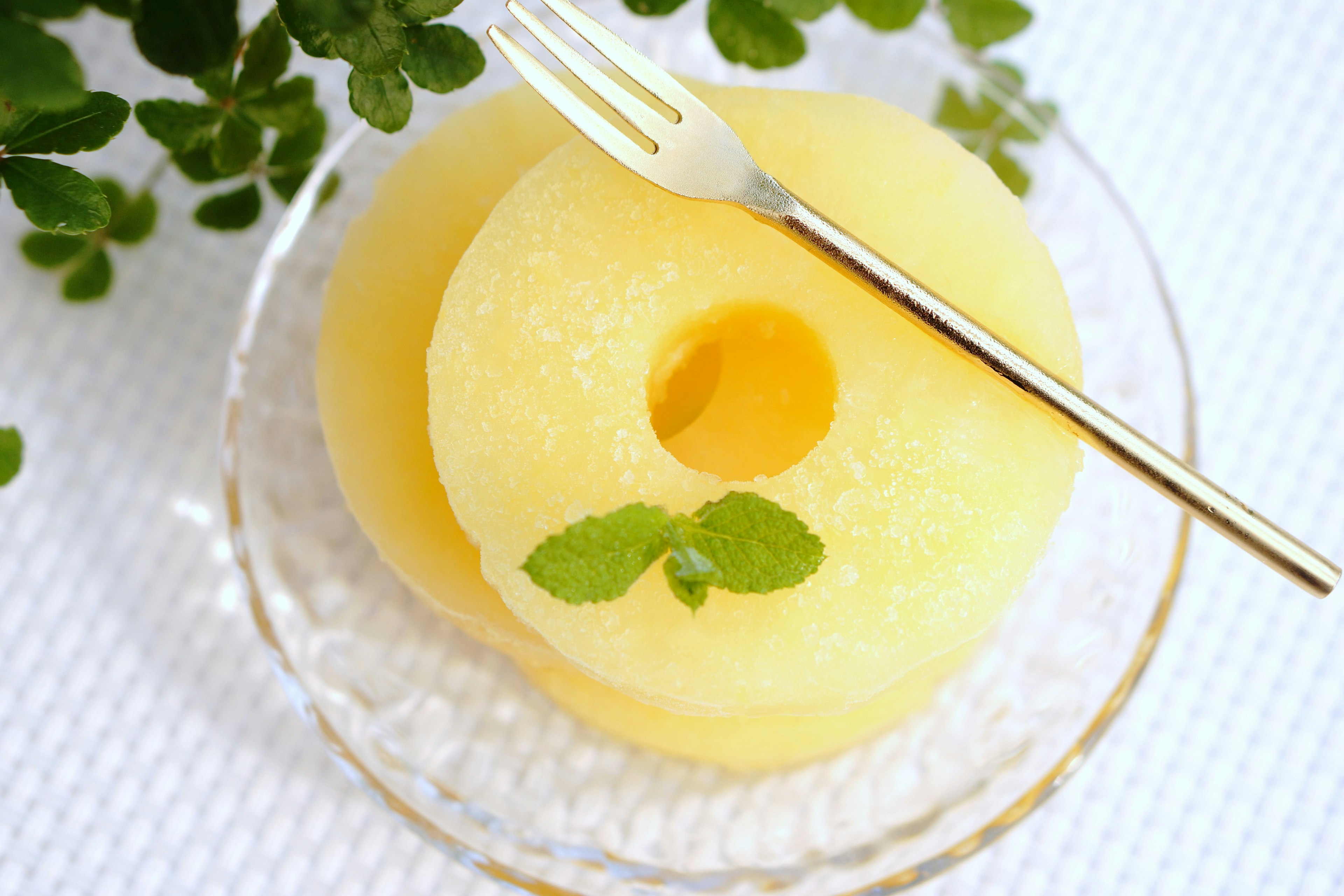 Yellow fruit slices on a clear plate with a fork