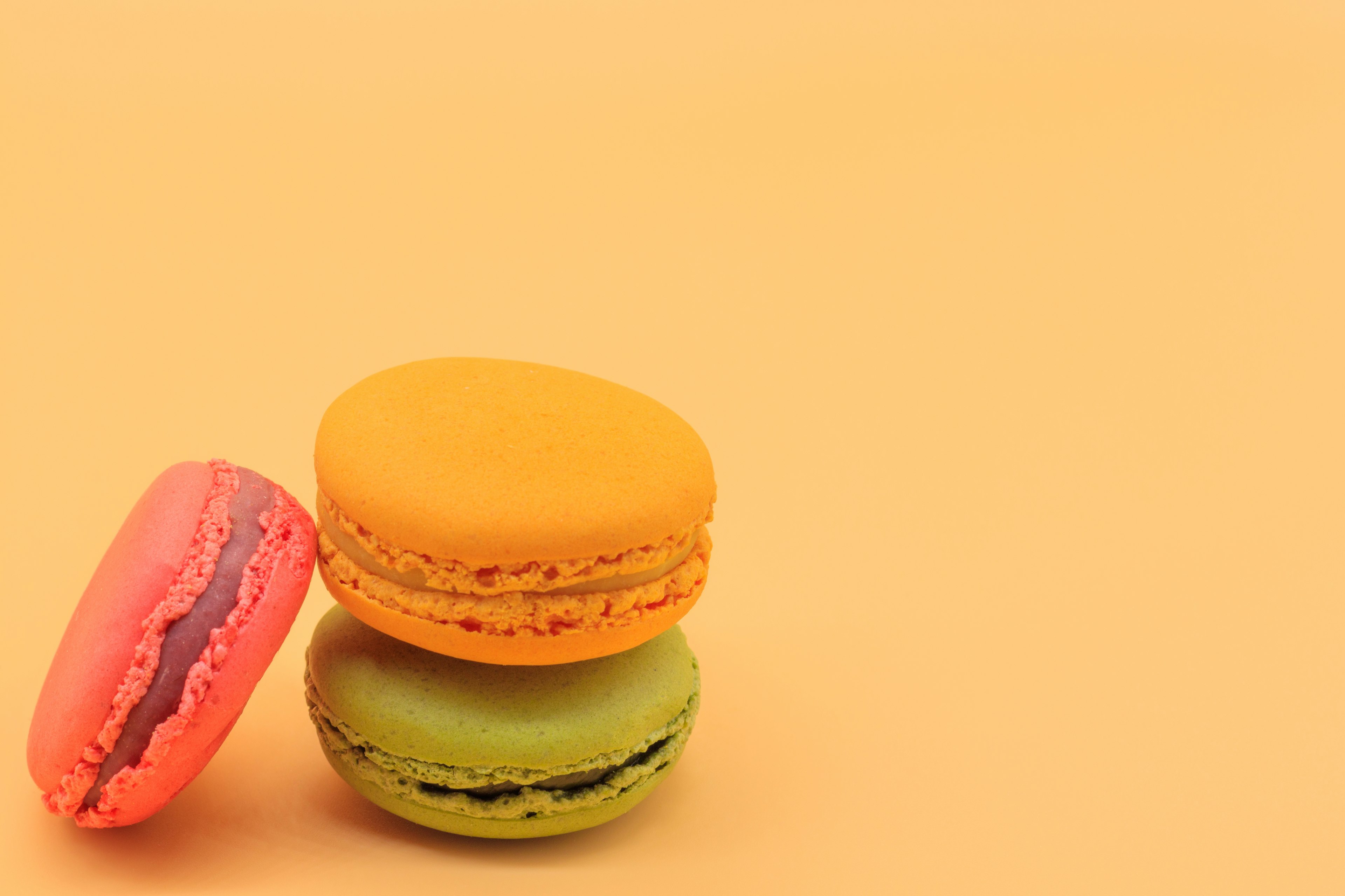 Colorful macarons stacked on an orange background