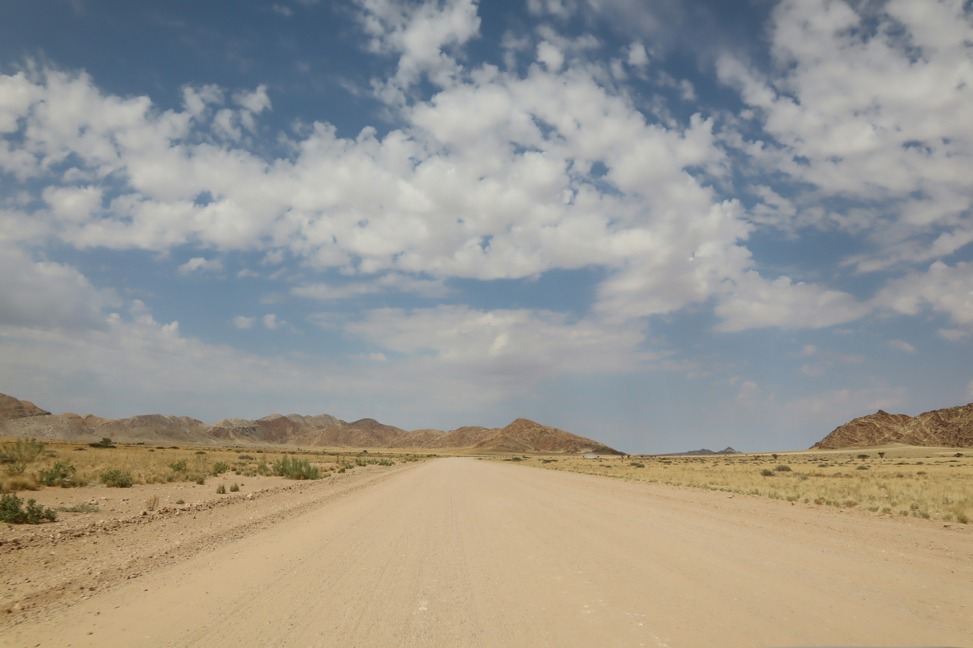 Camino del desierto con cielo azul y nubes