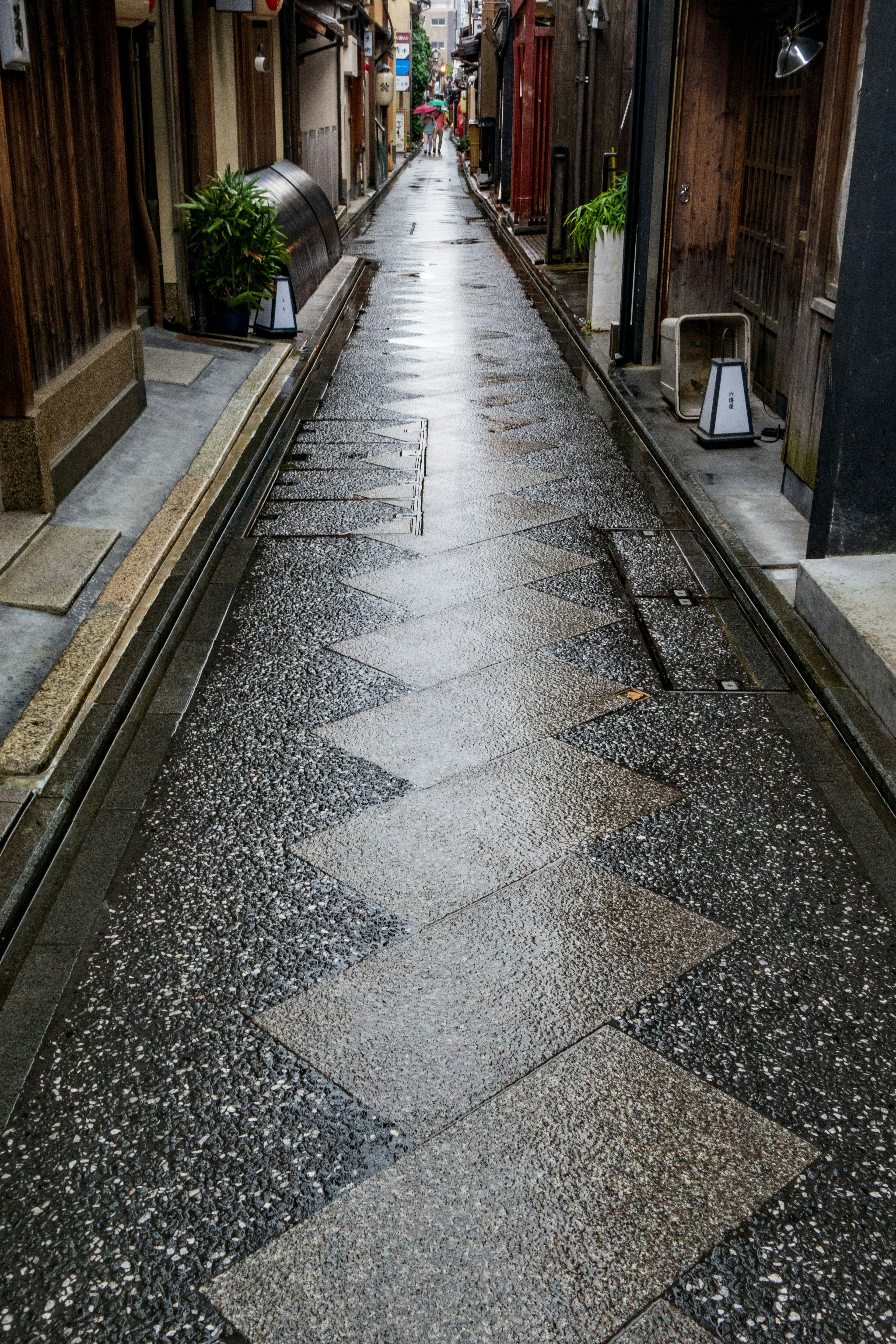 静かな雨に濡れた小道の風景 縞模様の石畳と周囲の古い建物