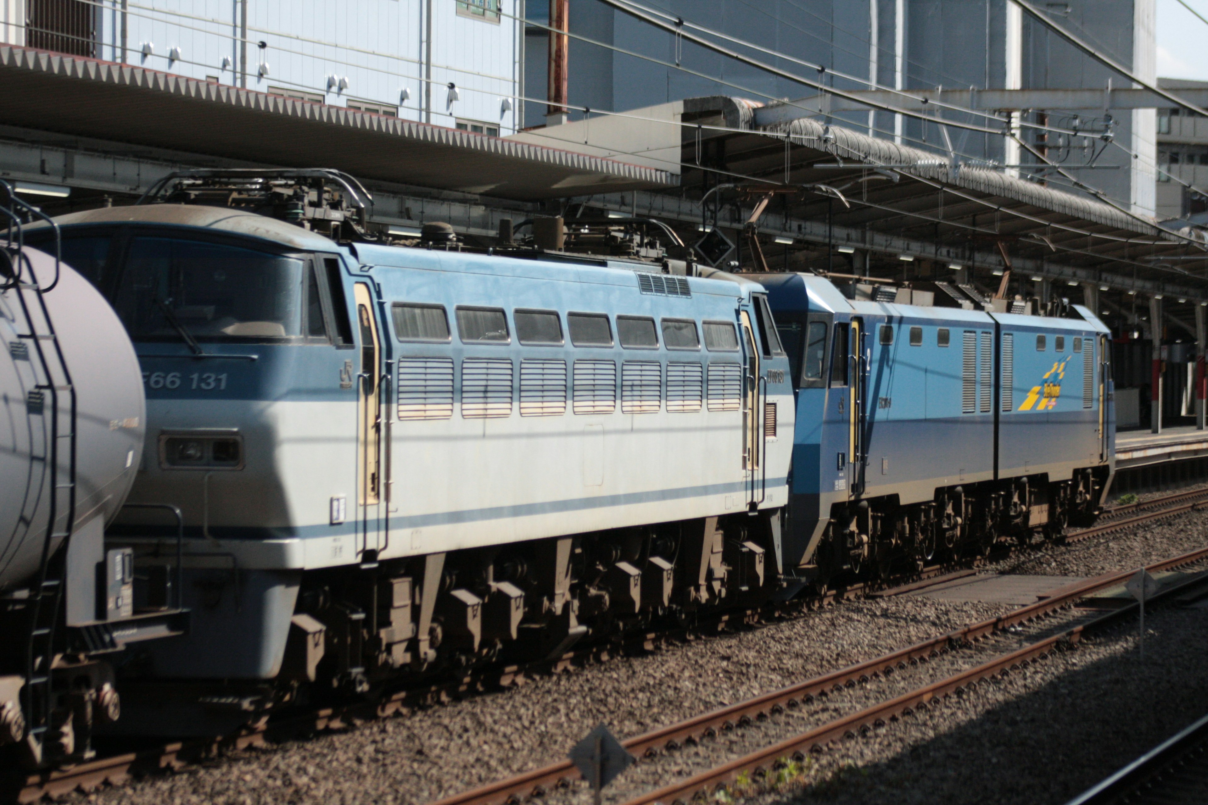 A blue locomotive parked at a train station