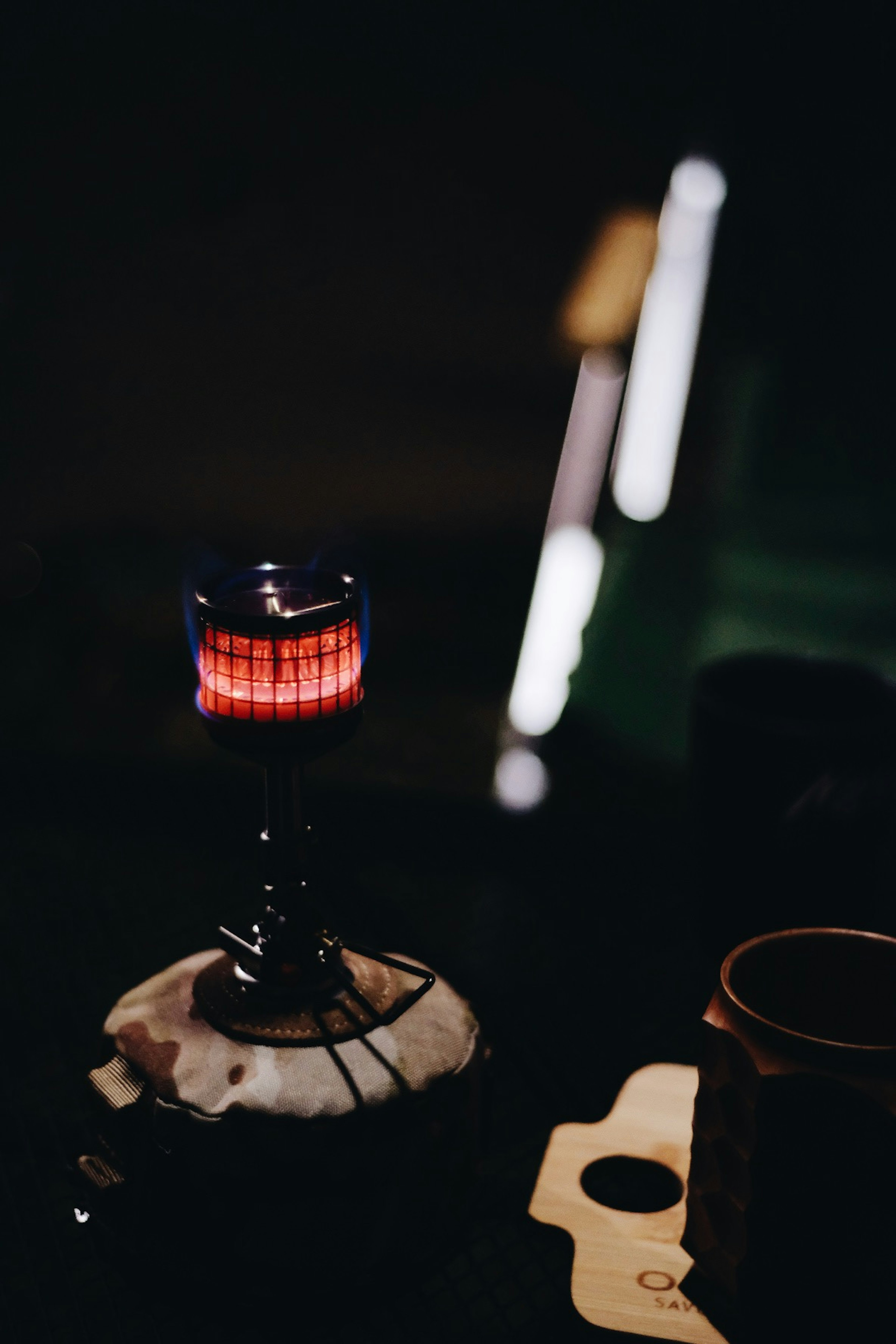 A small burner with a glowing red flame against a dark background