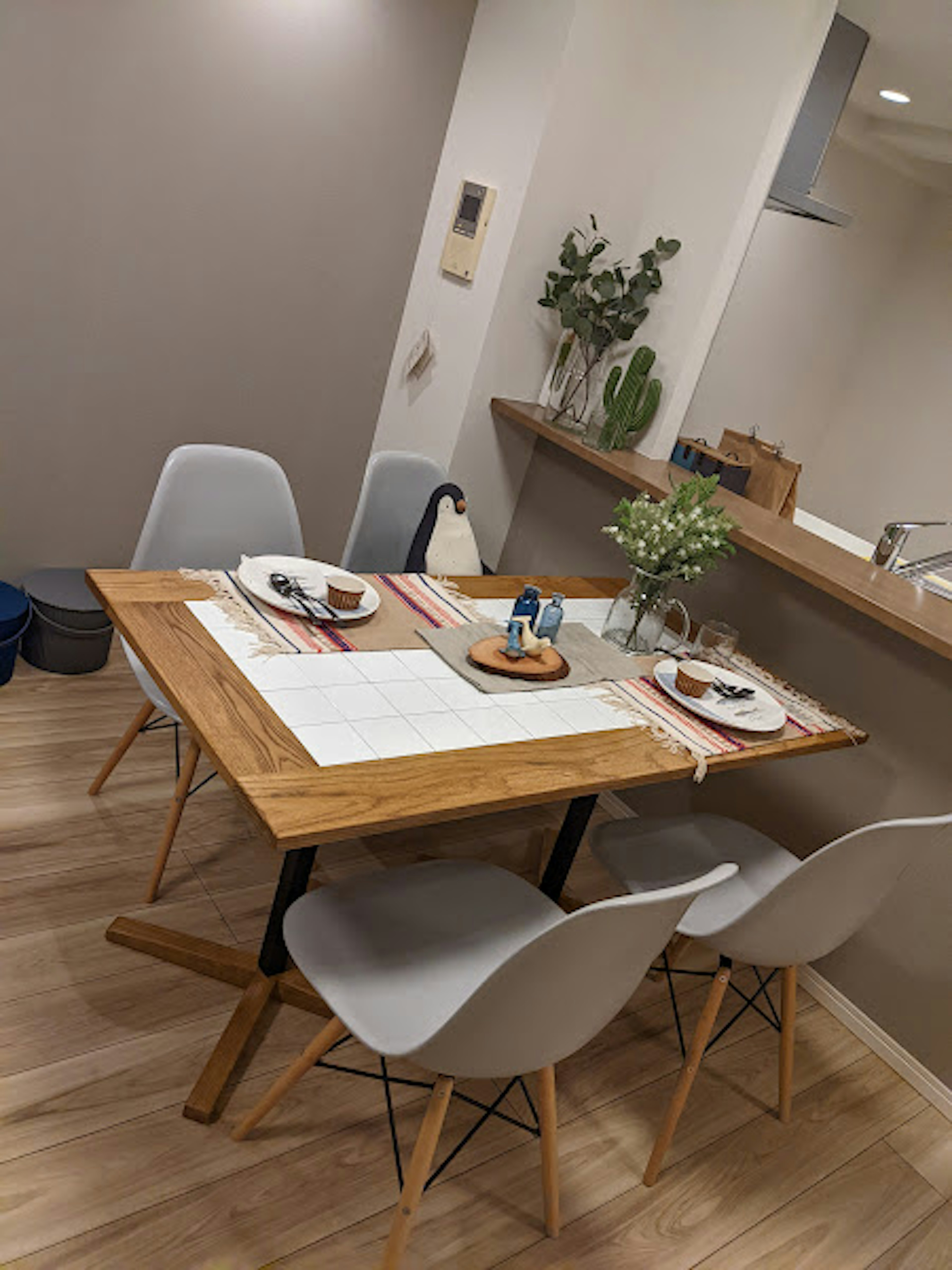 Intérieur de salle à manger moderne avec une table en bois dressée pour un repas et des plantes décoratives