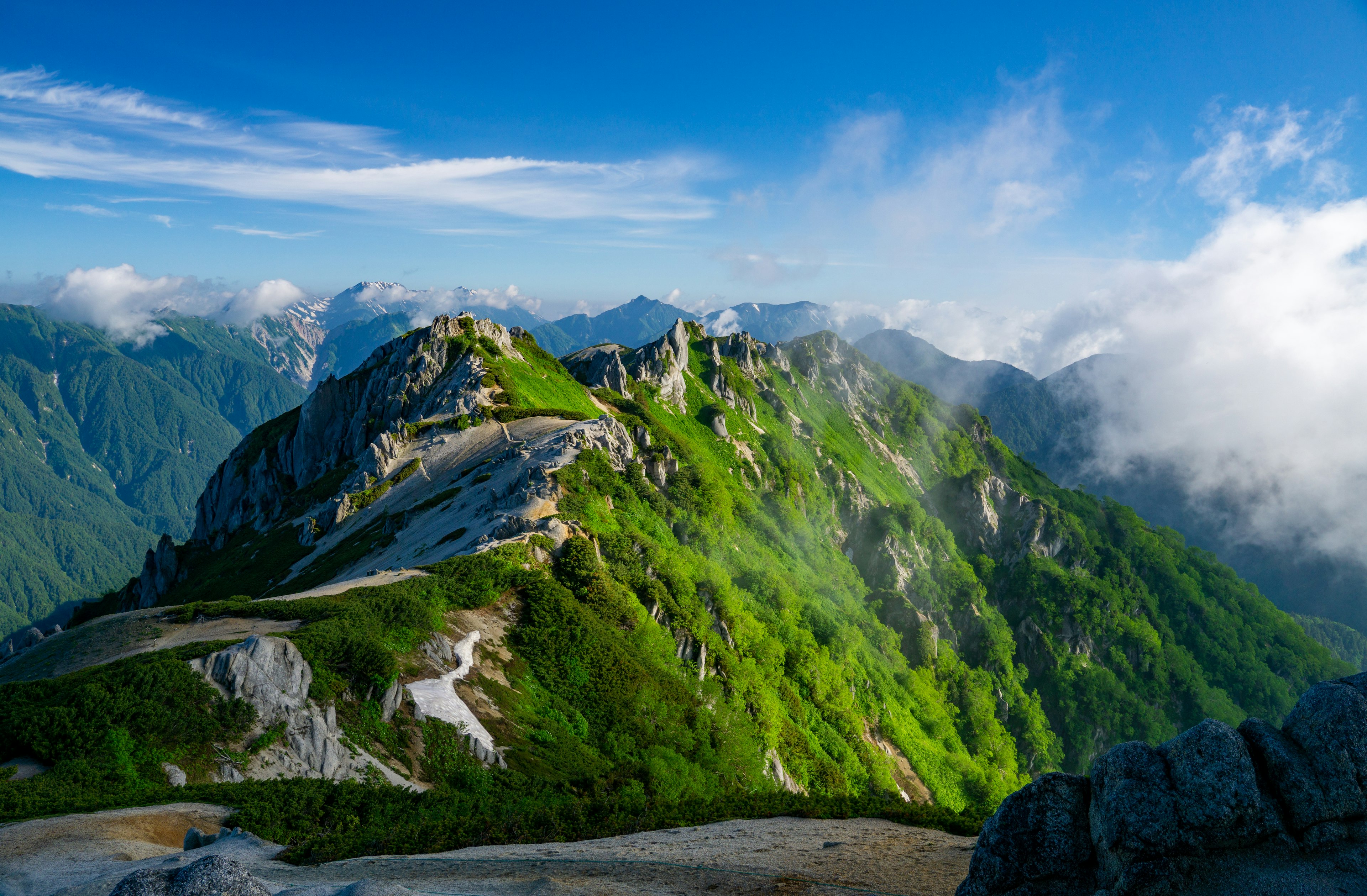 郁郁葱葱的绿色山脉与蓝天，令人印象深刻的山峰和云朵