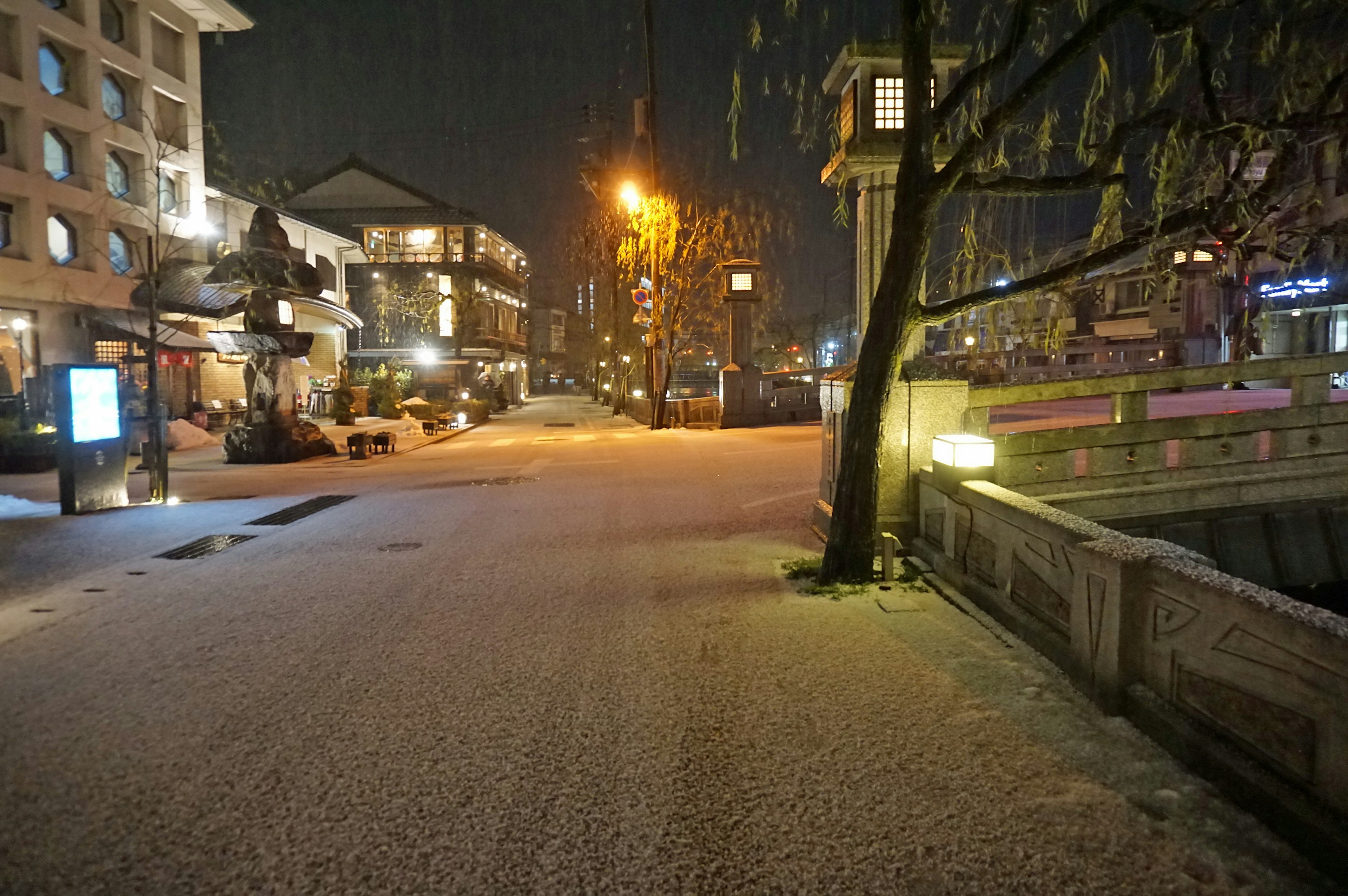 雪に覆われた夜の街並みに輝く街灯と静かな通り