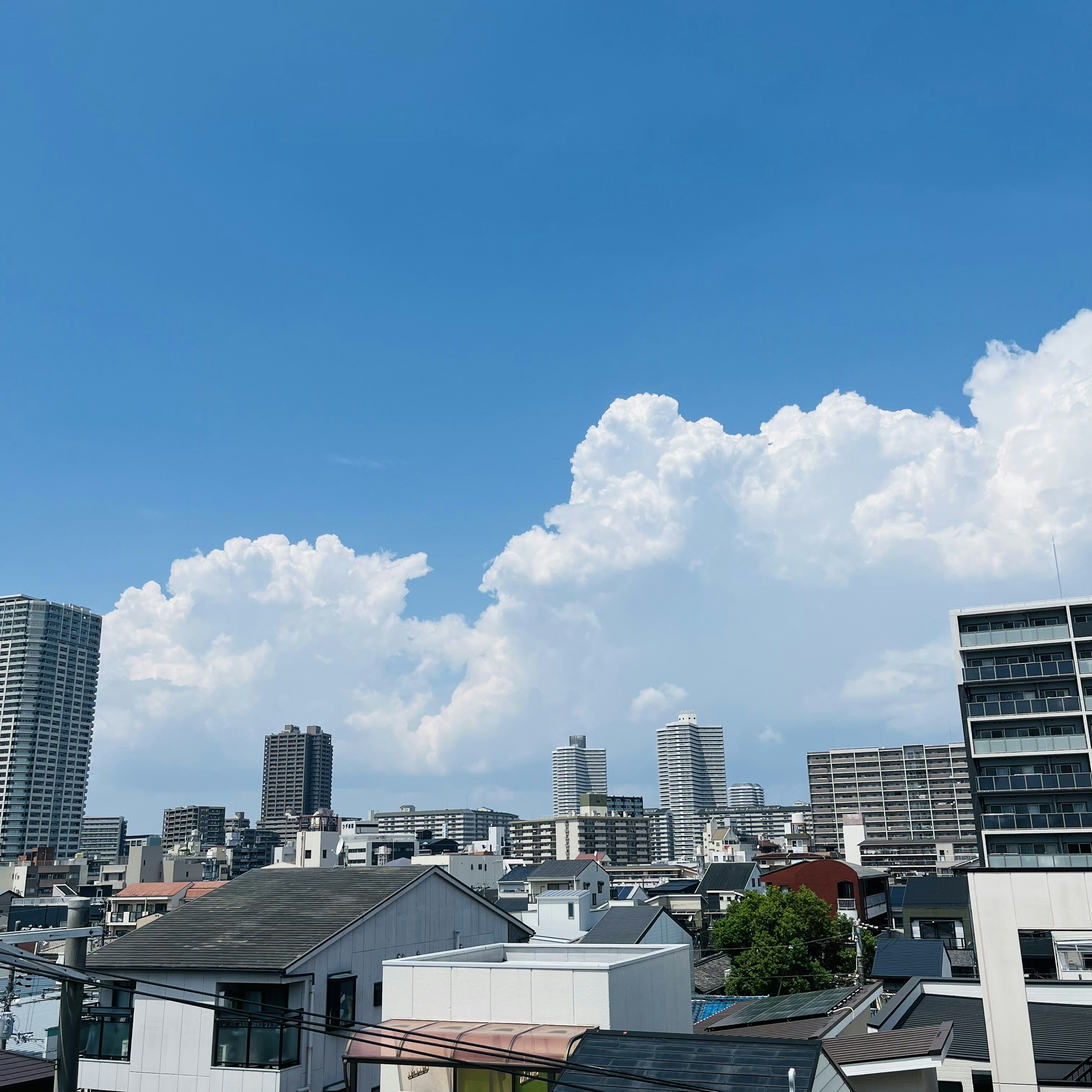 Paysage urbain avec des grands bâtiments et des maisons sous un ciel bleu clair avec des nuages blancs moelleux