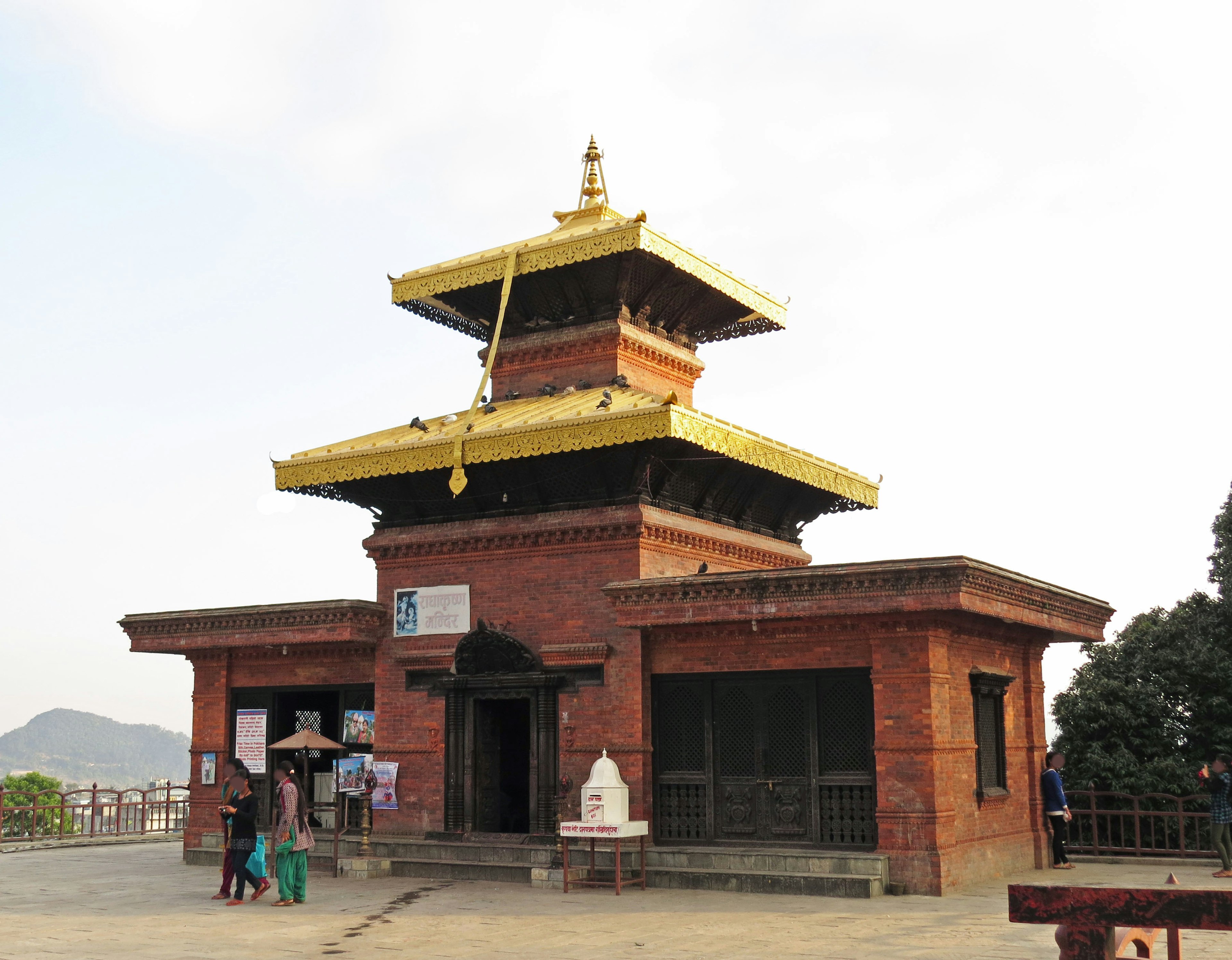 Temple en briques avec un toit doré et paysage environnant