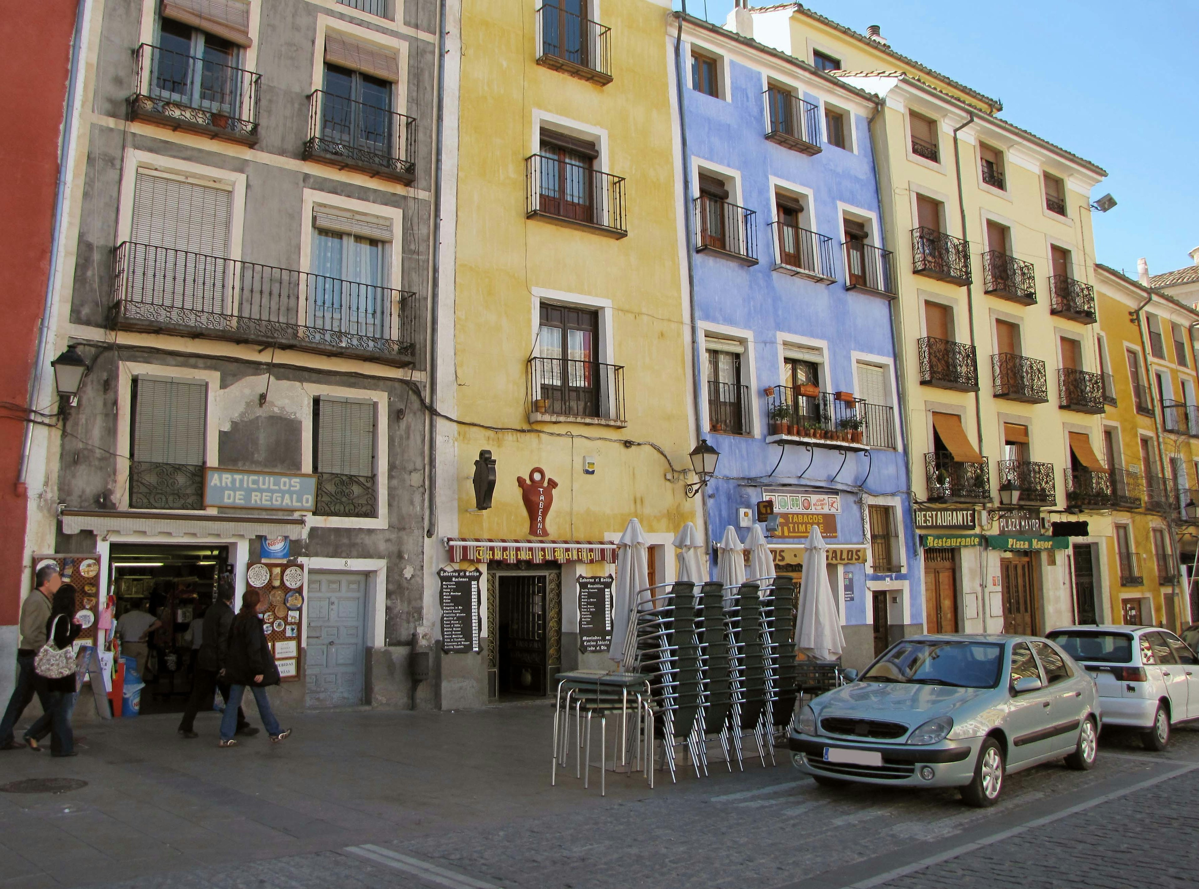 Colorful buildings lining a plaza with people walking