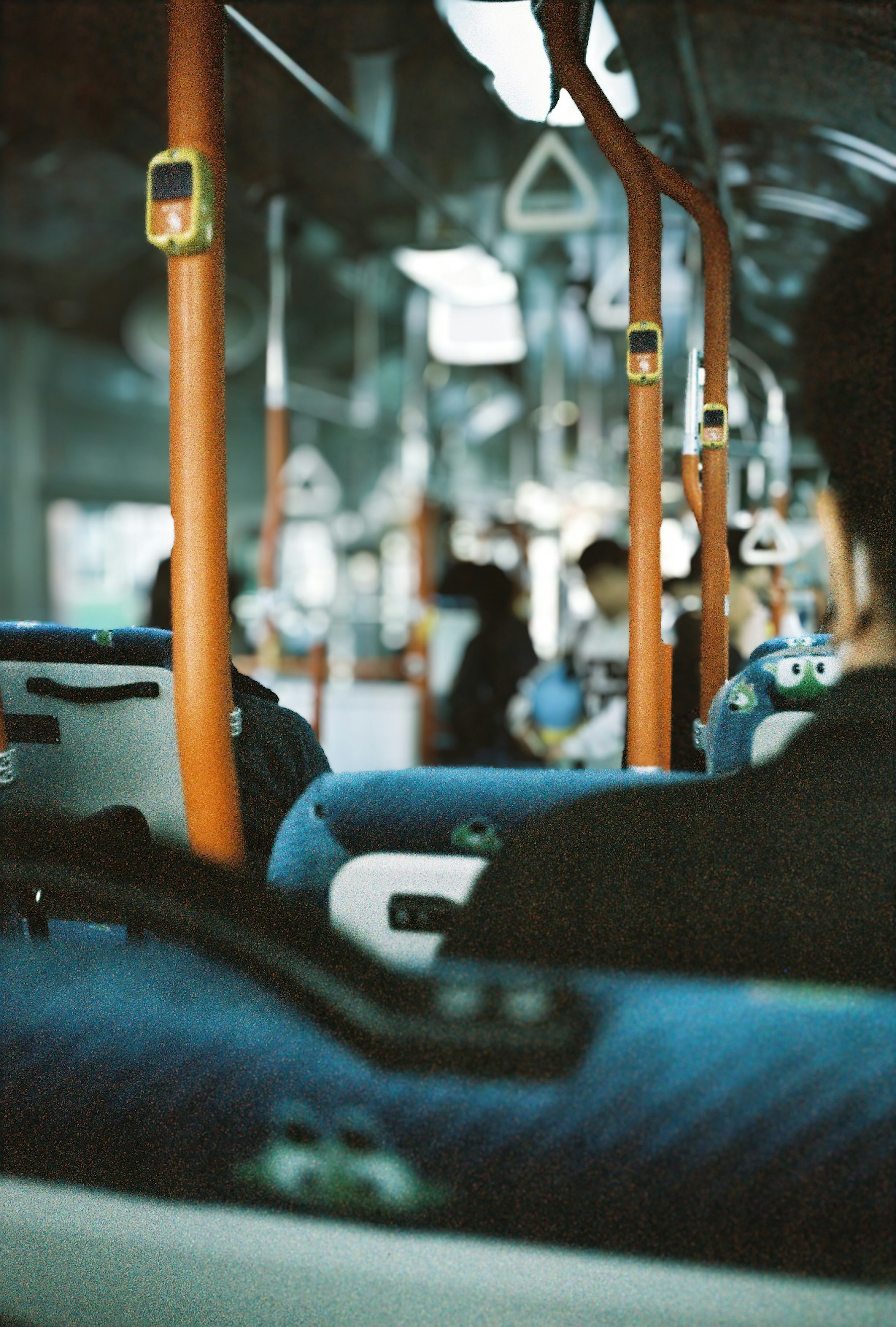 Interior view of a bus featuring blue seats and orange handrails