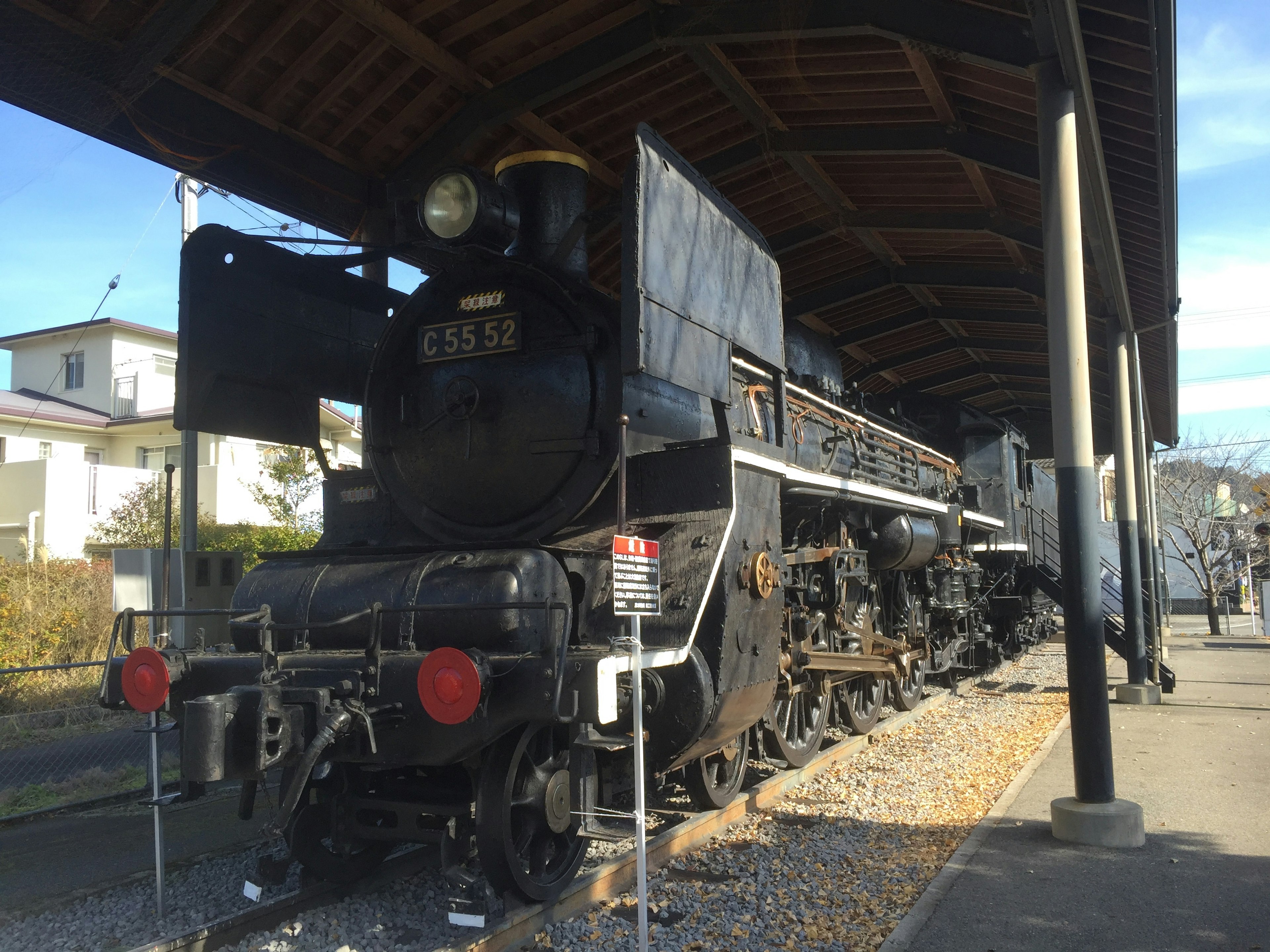 Eine alte Dampflokomotive, die unter einem Bahnhofsdach steht