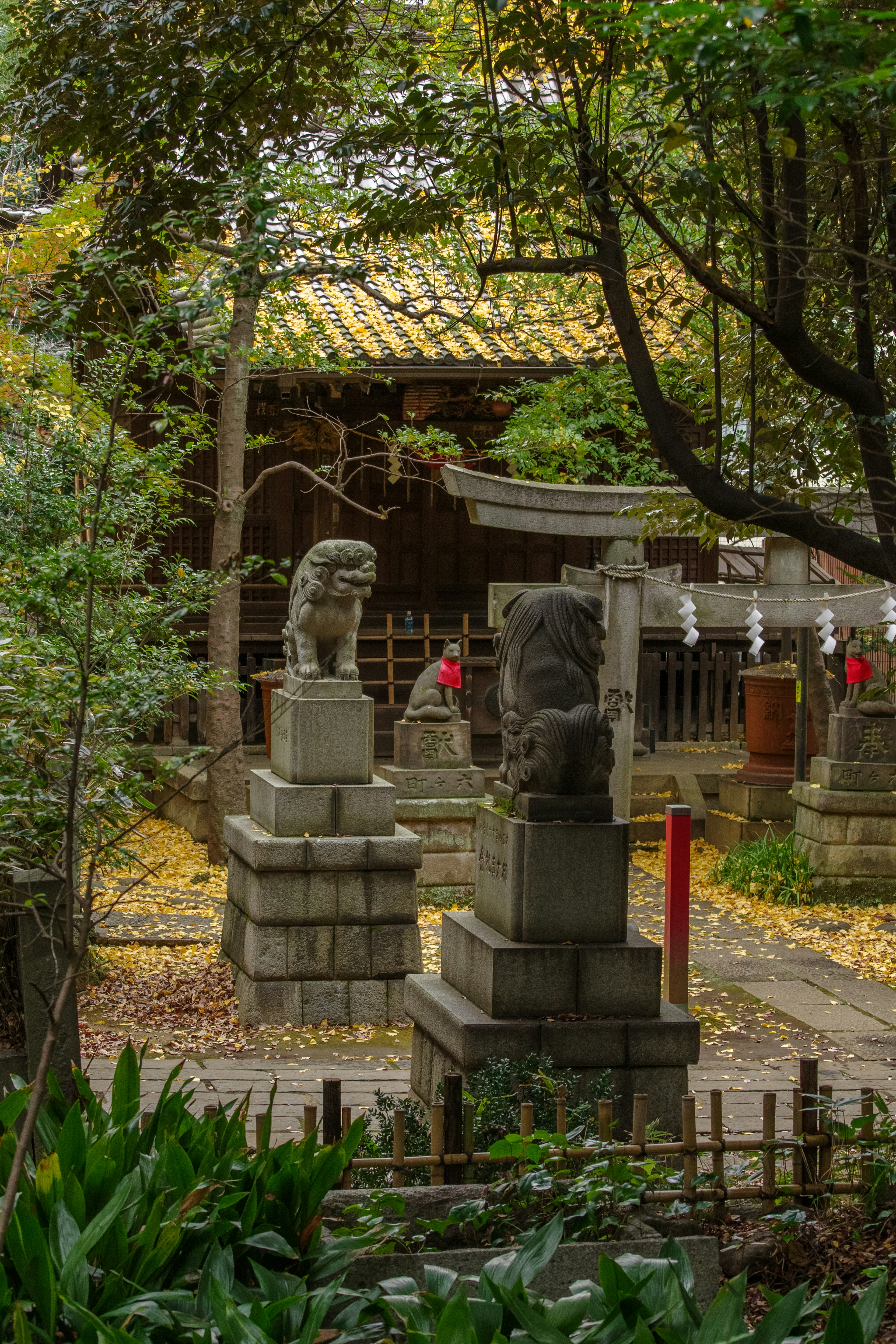 Estatuas de leones de piedra en un jardín de santuario rodeado de árboles