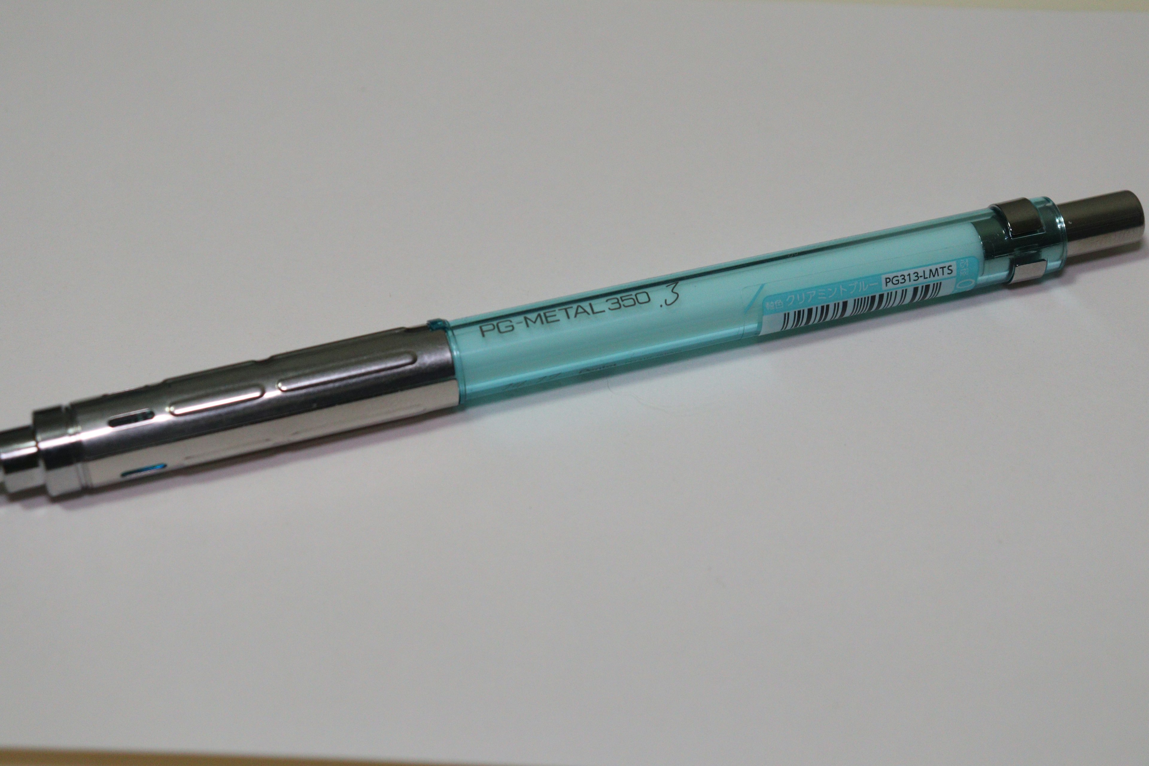 A blue barrel ballpoint pen resting on a white background