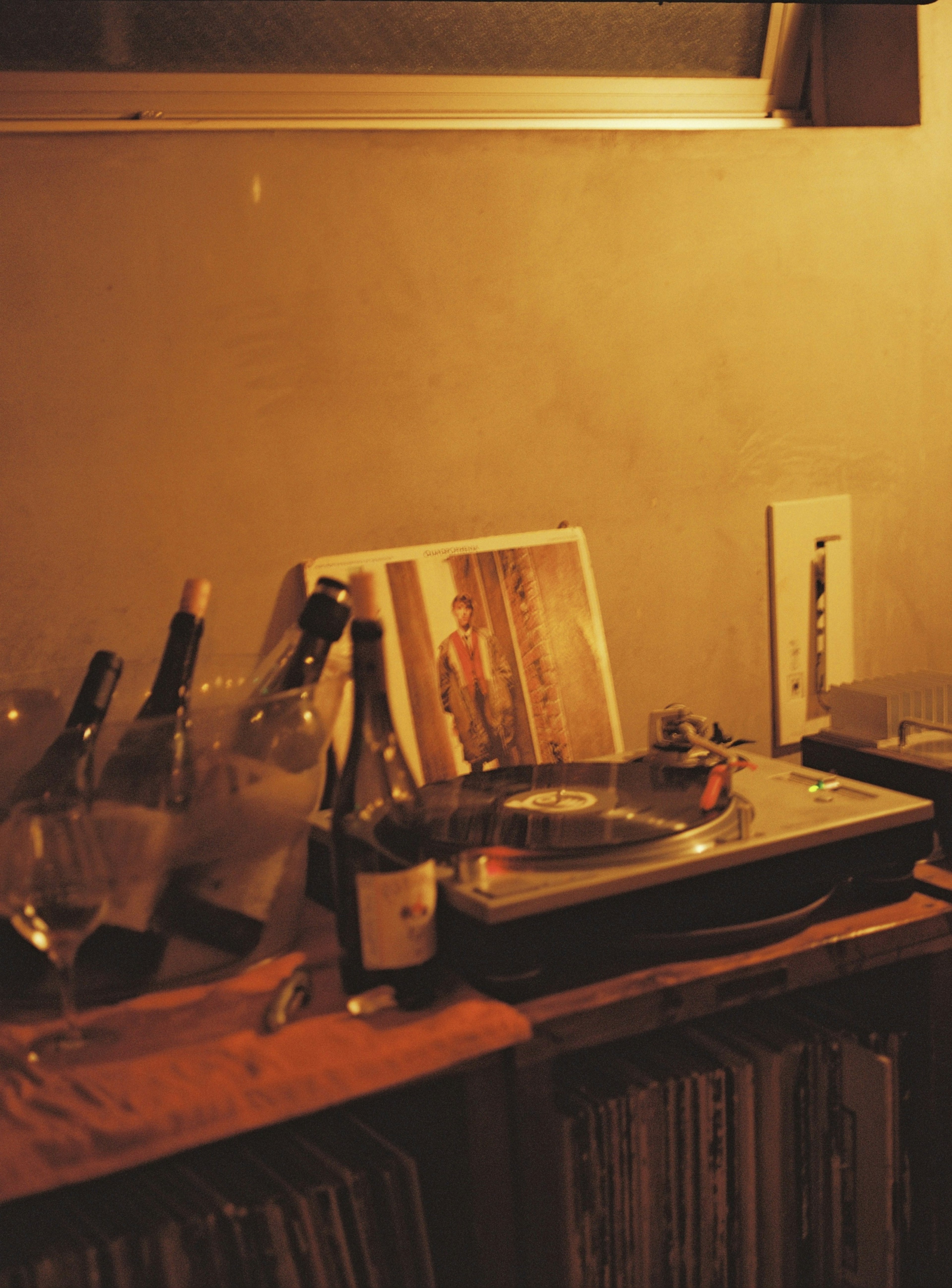 Cozy corner featuring a turntable and wine bottles