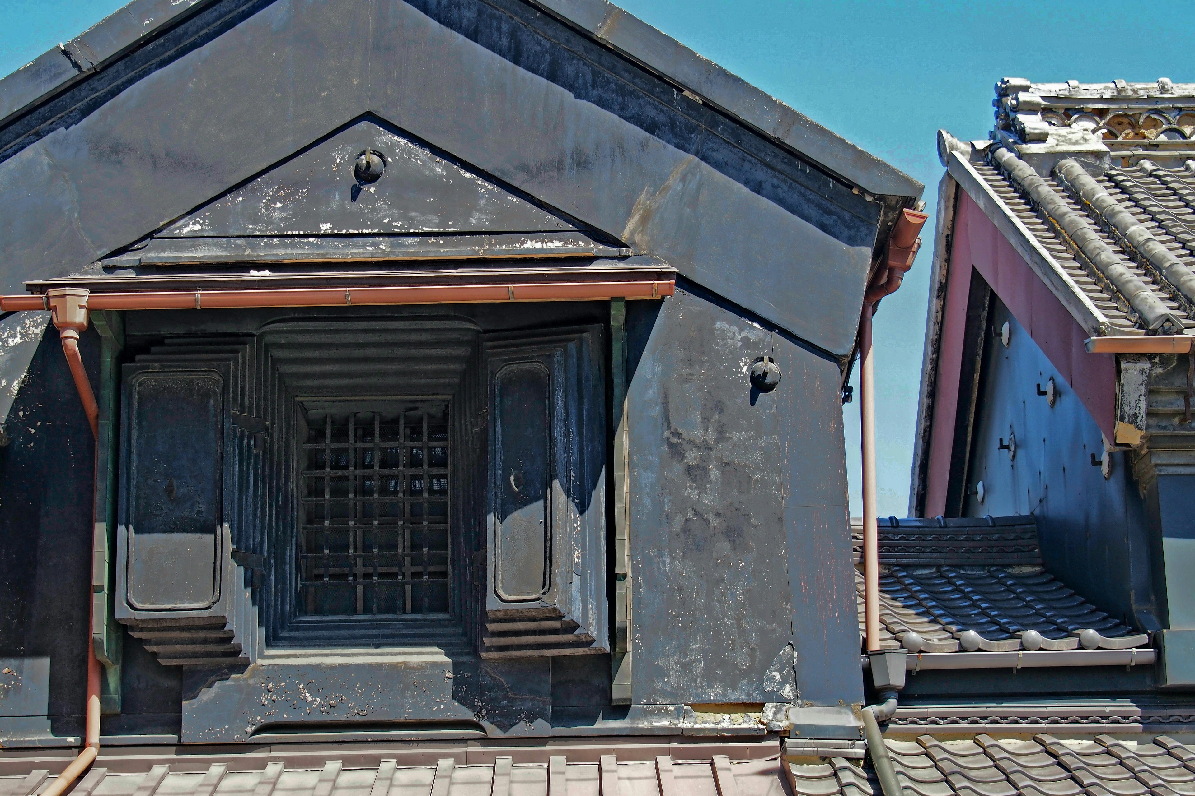 Traditional Japanese building with distinctive black roof and window