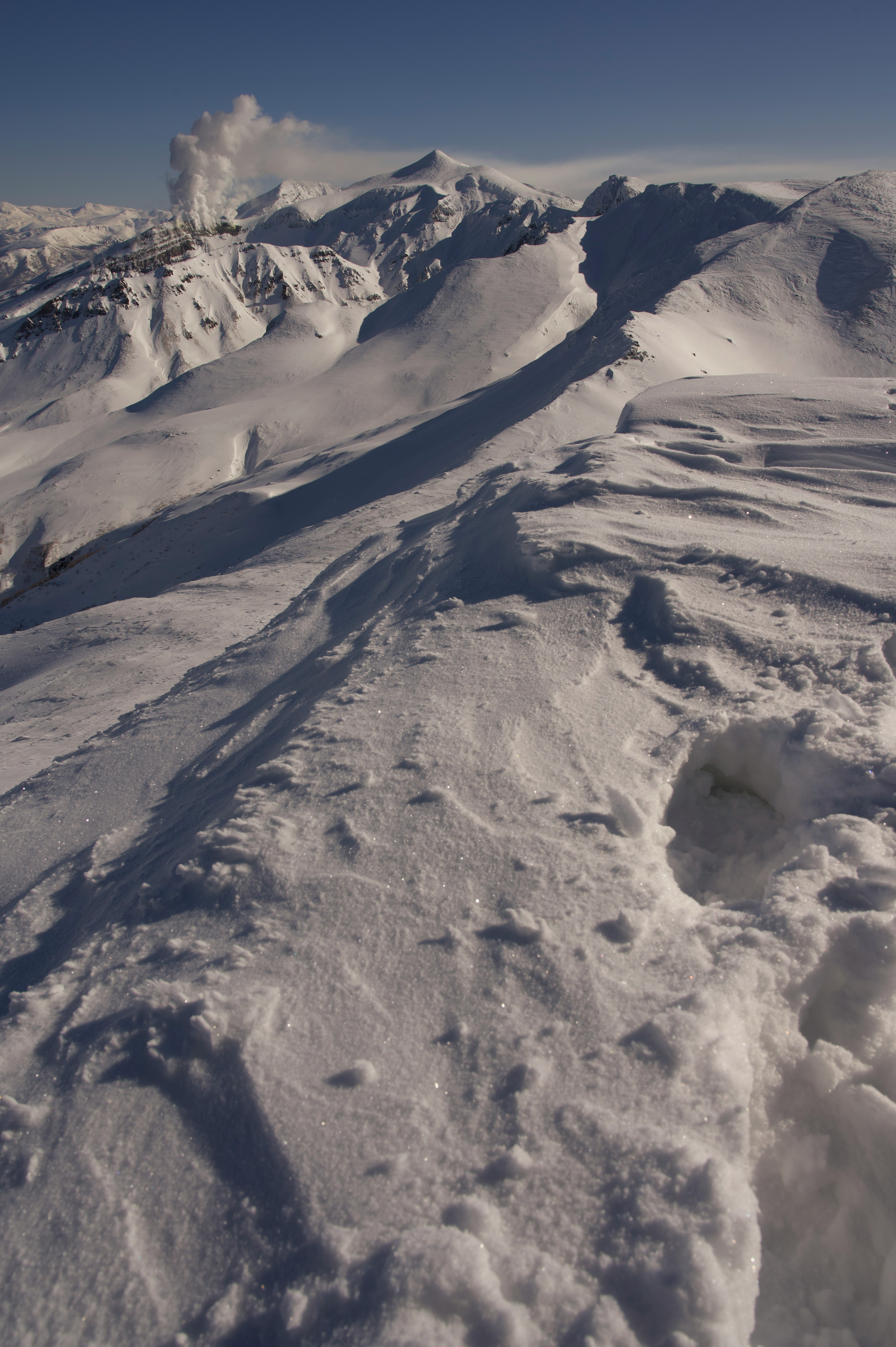 Snow-covered mountain landscape with clear blue sky