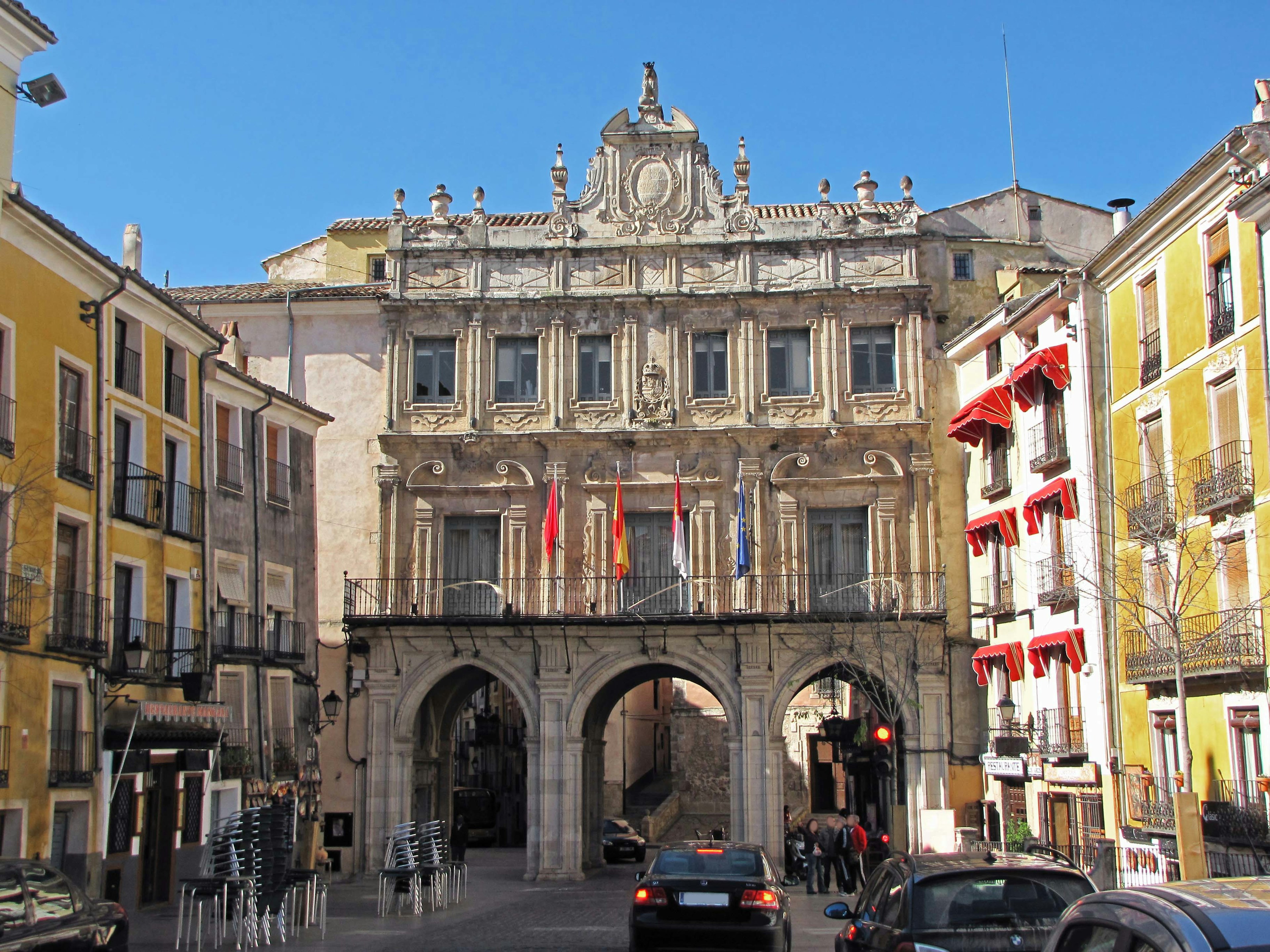 Arco que lleva a un gran edificio rodeado de estructuras coloridas