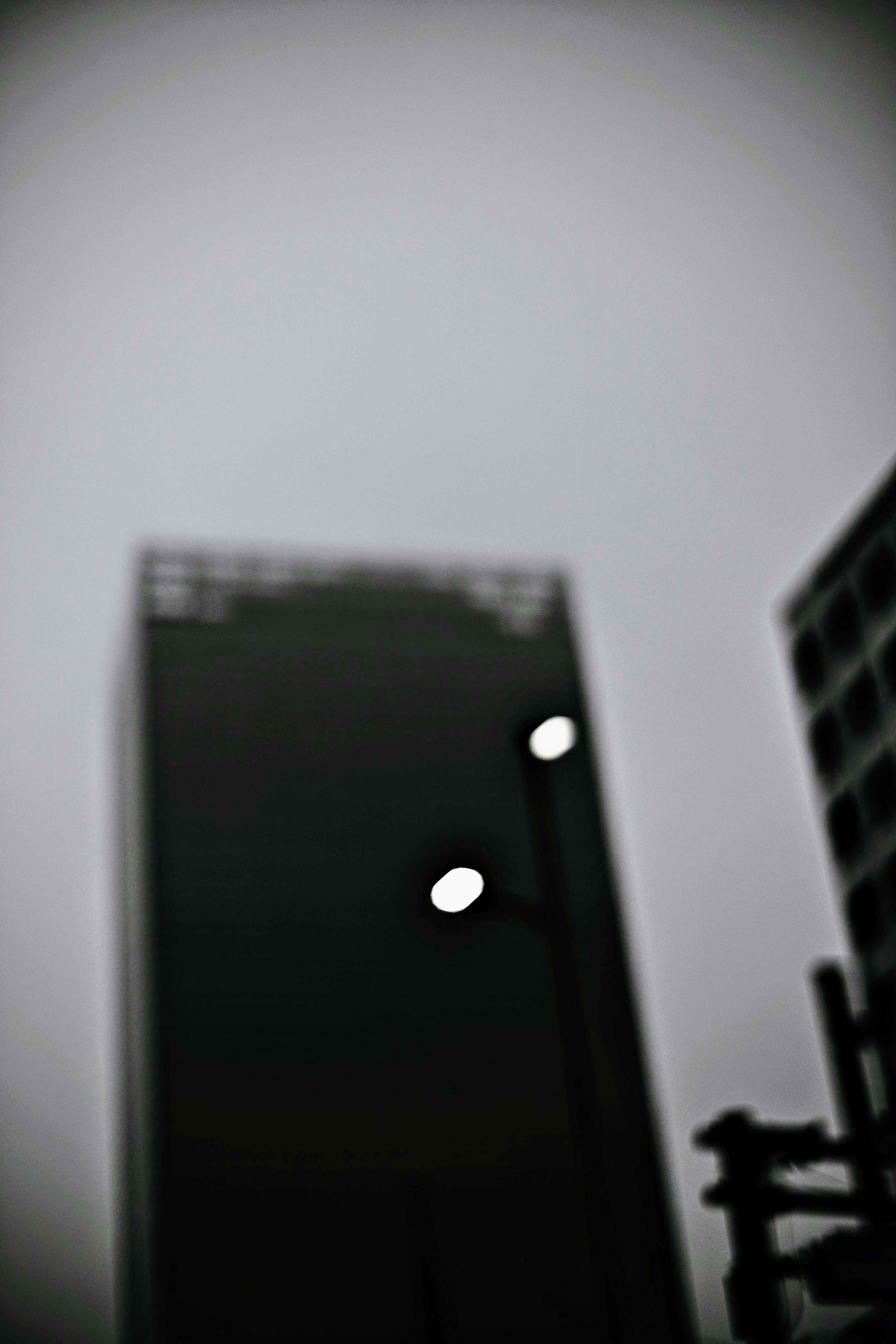 Blurred silhouette of skyscraper and streetlights in monochrome