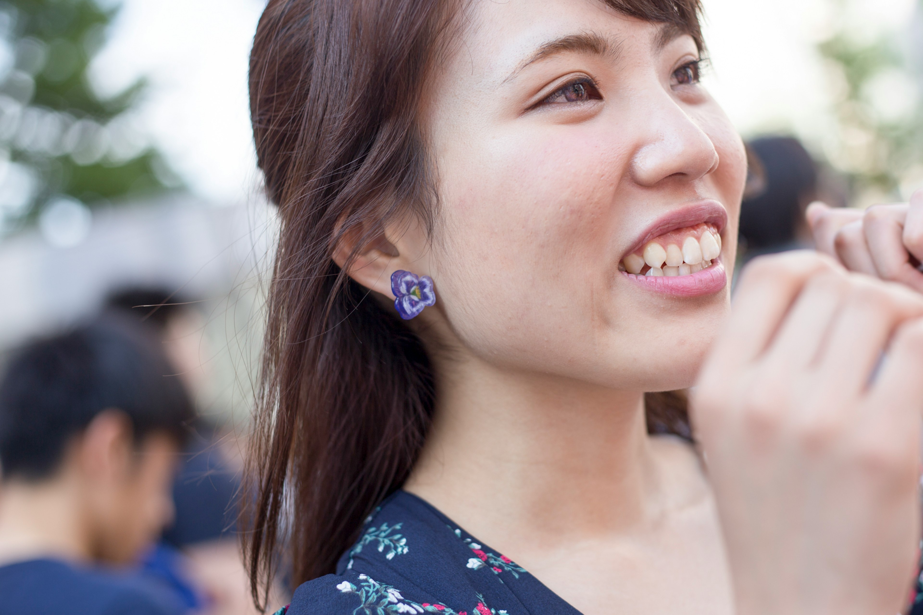 Femme souriante portant des boucles d'oreilles violettes