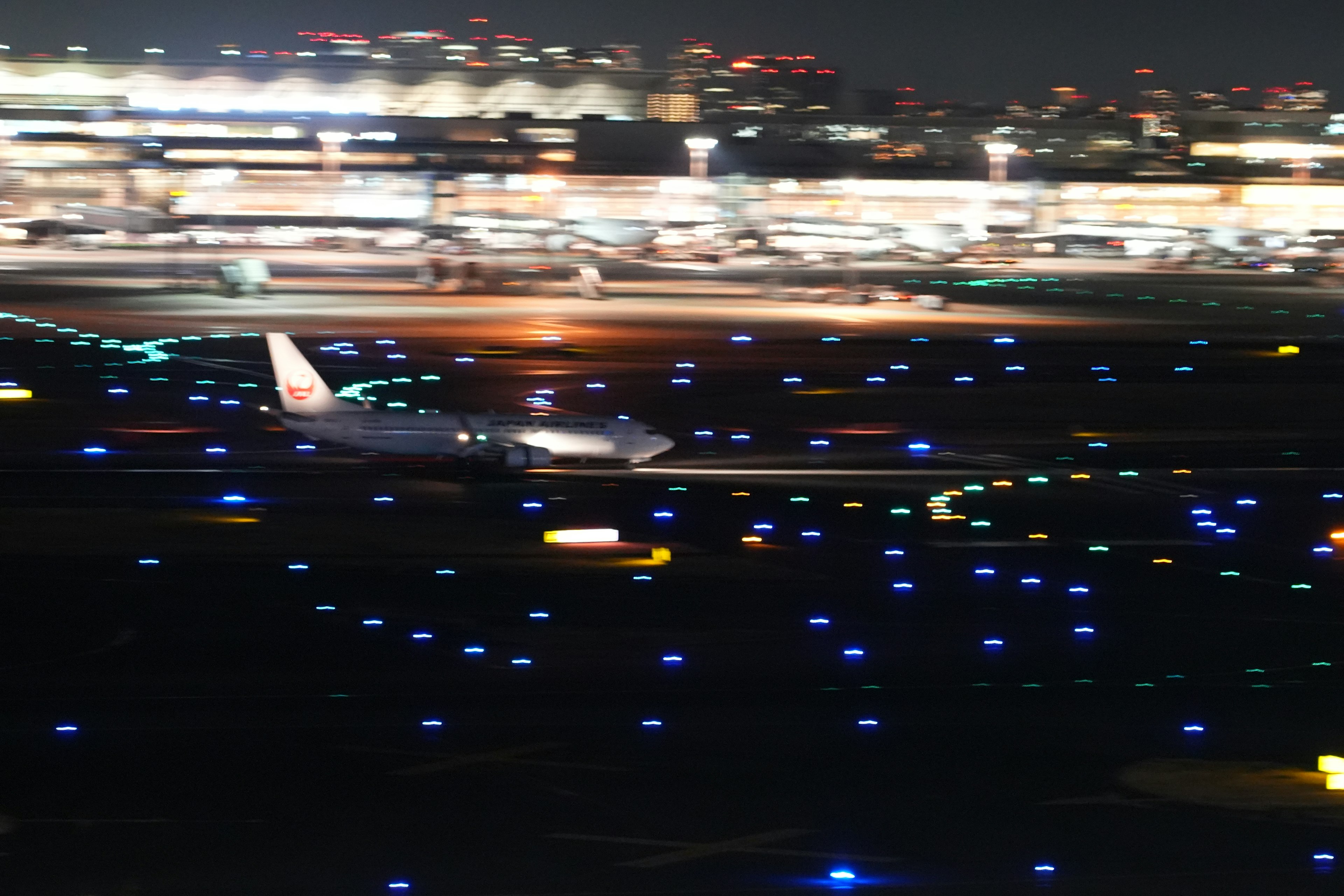 Aereo su una pista circondato da luci blu di notte