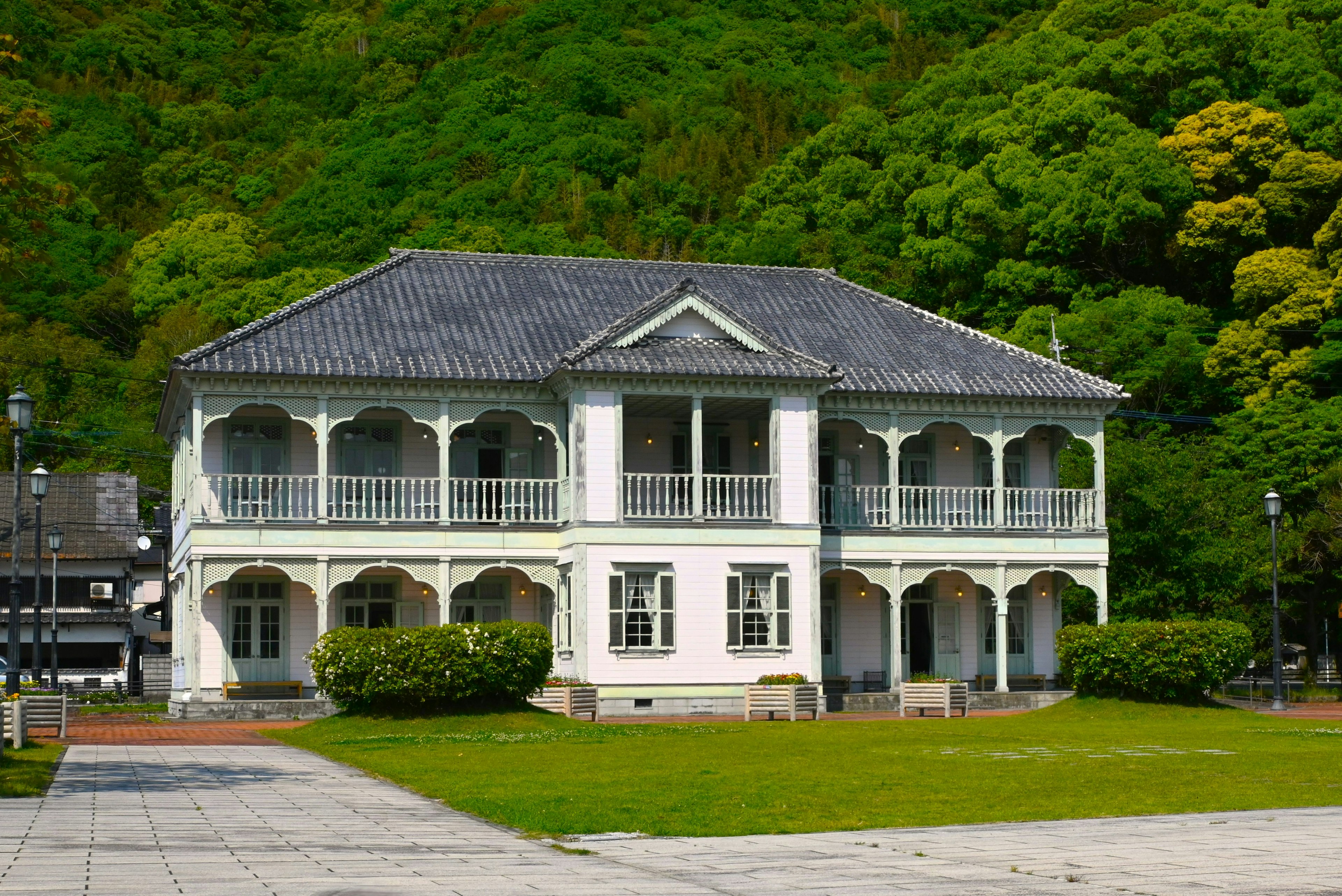 緑の背景に立つ白い西洋風の建物