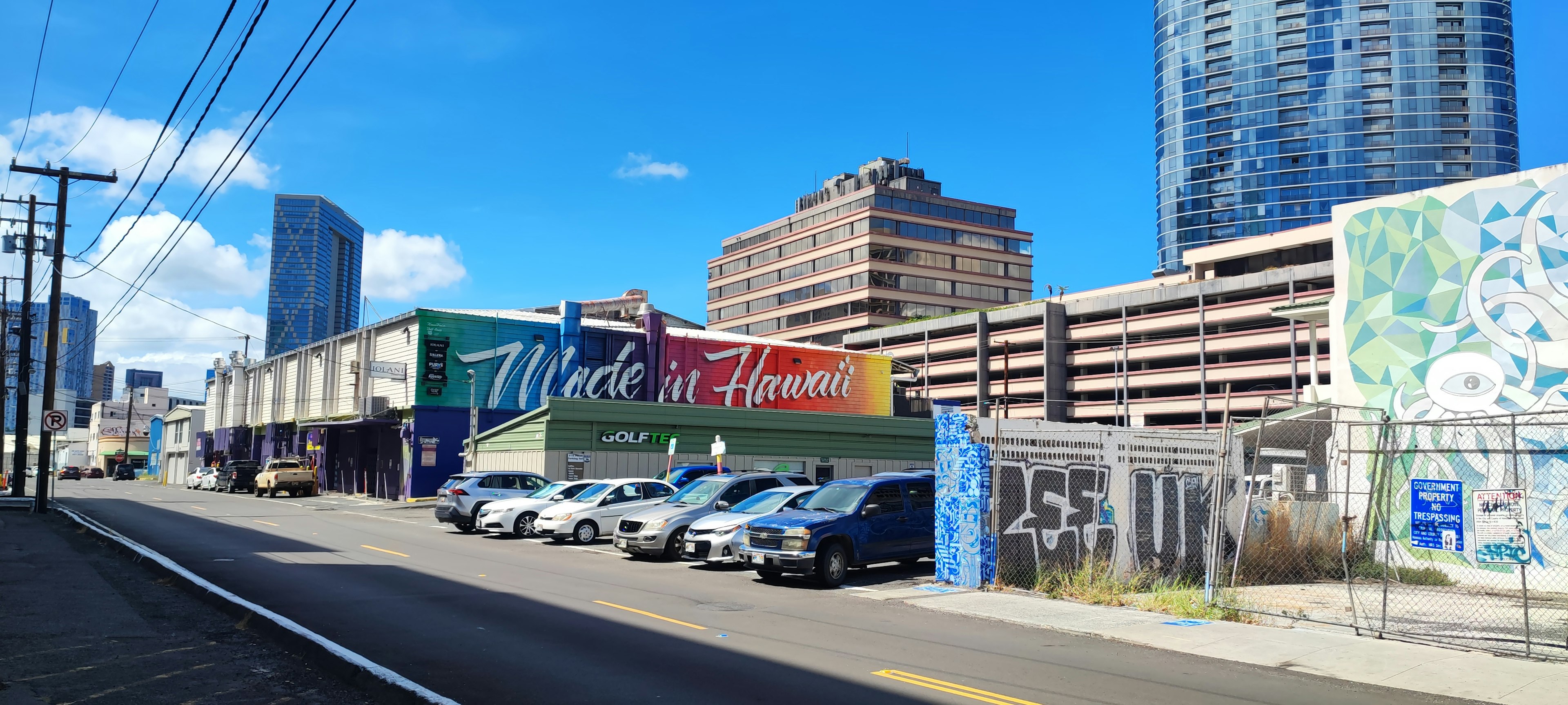 Urban landscape featuring buildings with murals and parked cars