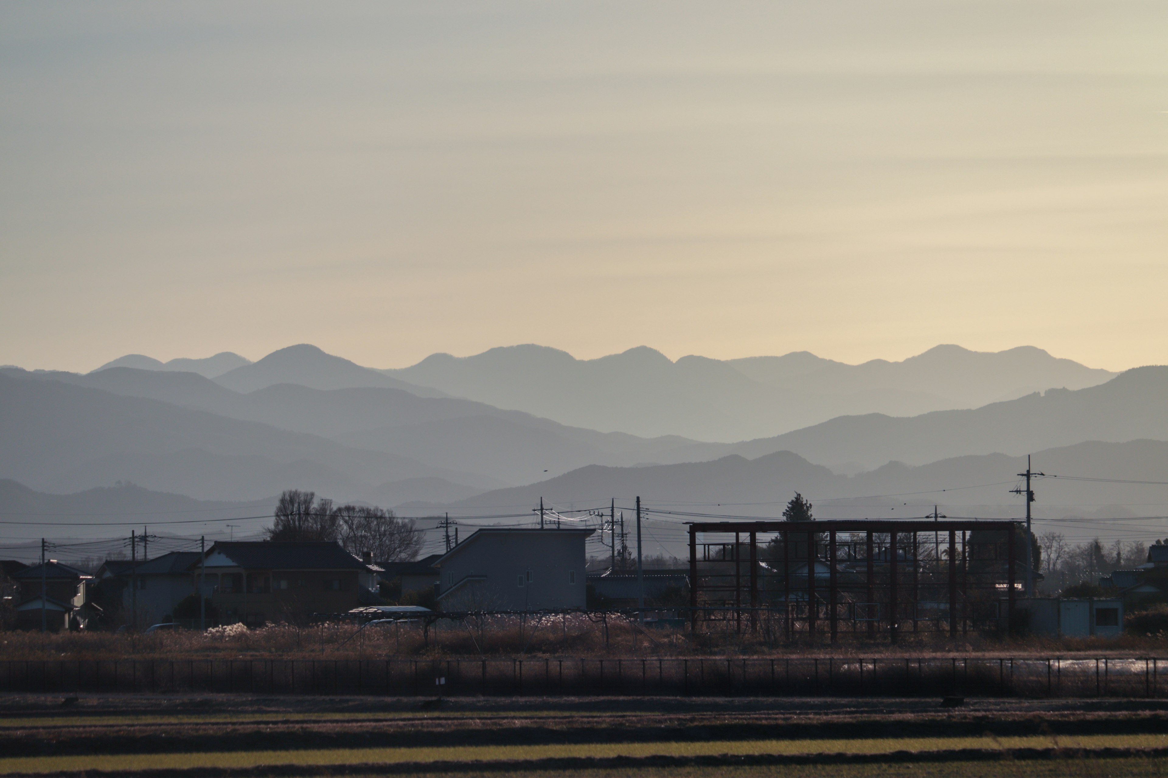 Un paisaje sereno con montañas al fondo y edificios rurales en primer plano