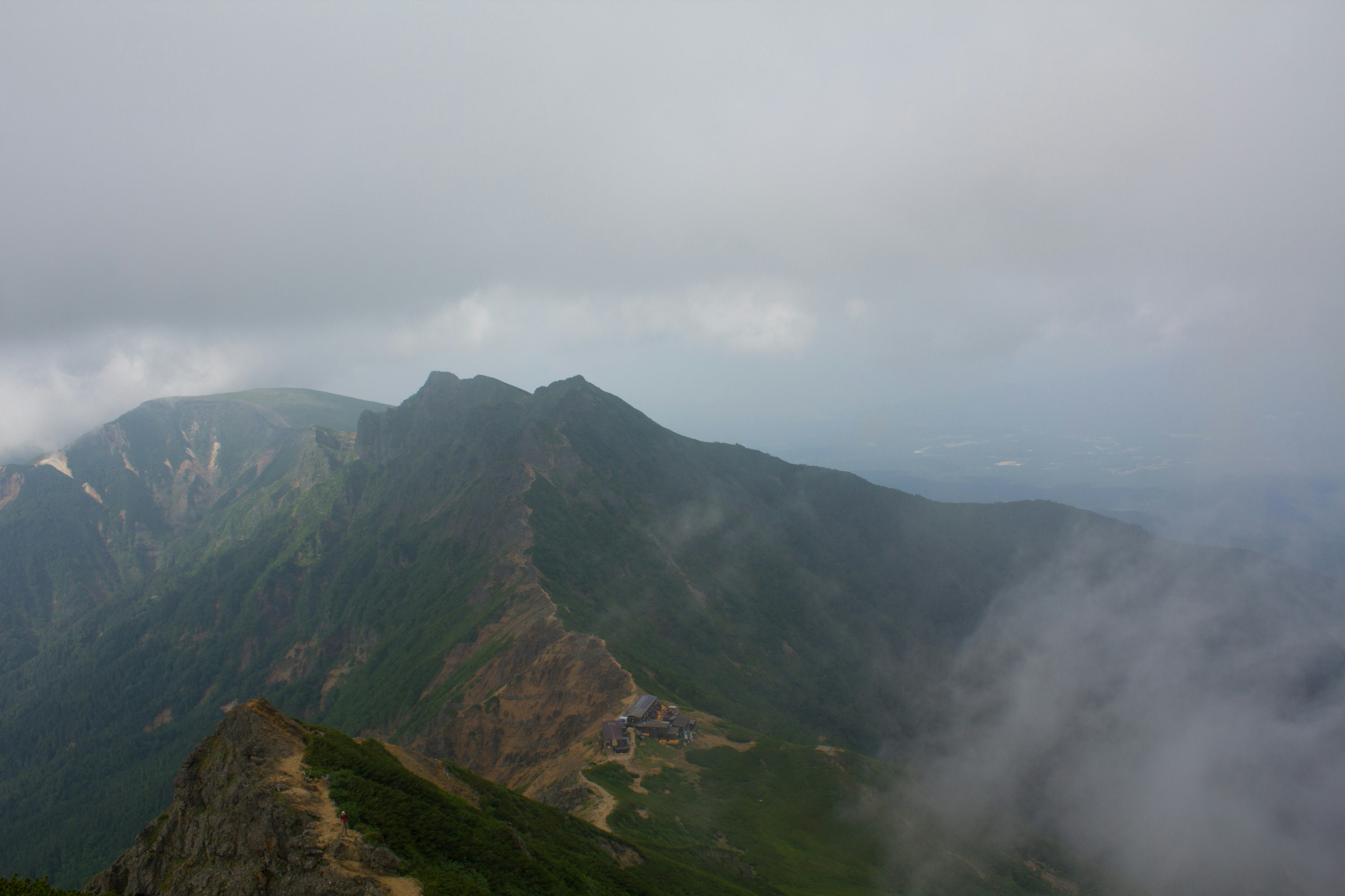 Paysage de montagne enveloppé de brume avec des vallées verdoyantes