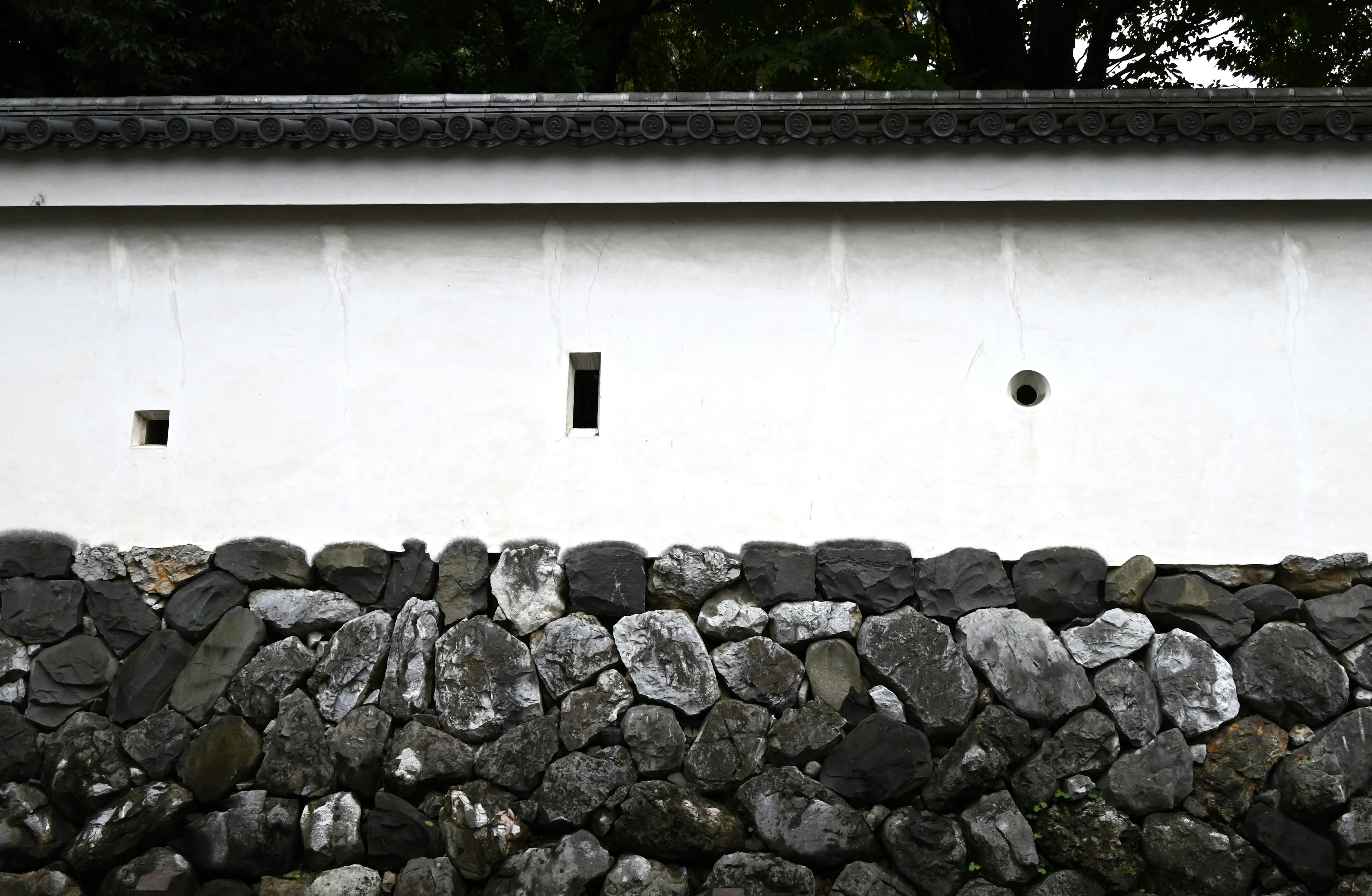 Traditionelles Gebäude mit weißer Wand und Steinfundament