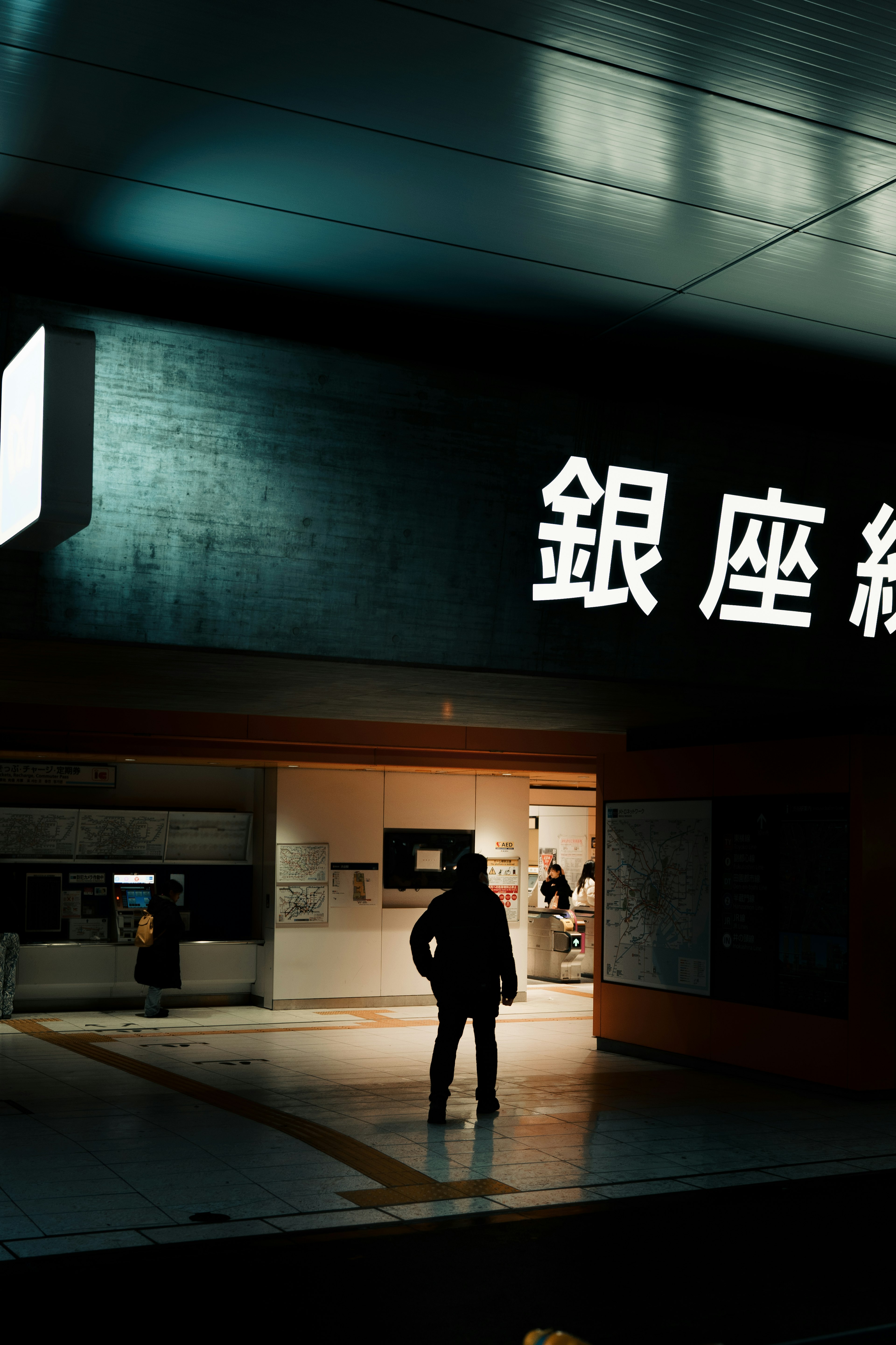 Silueta de una persona en la entrada de la estación de la línea Ginza con un letrero brillante