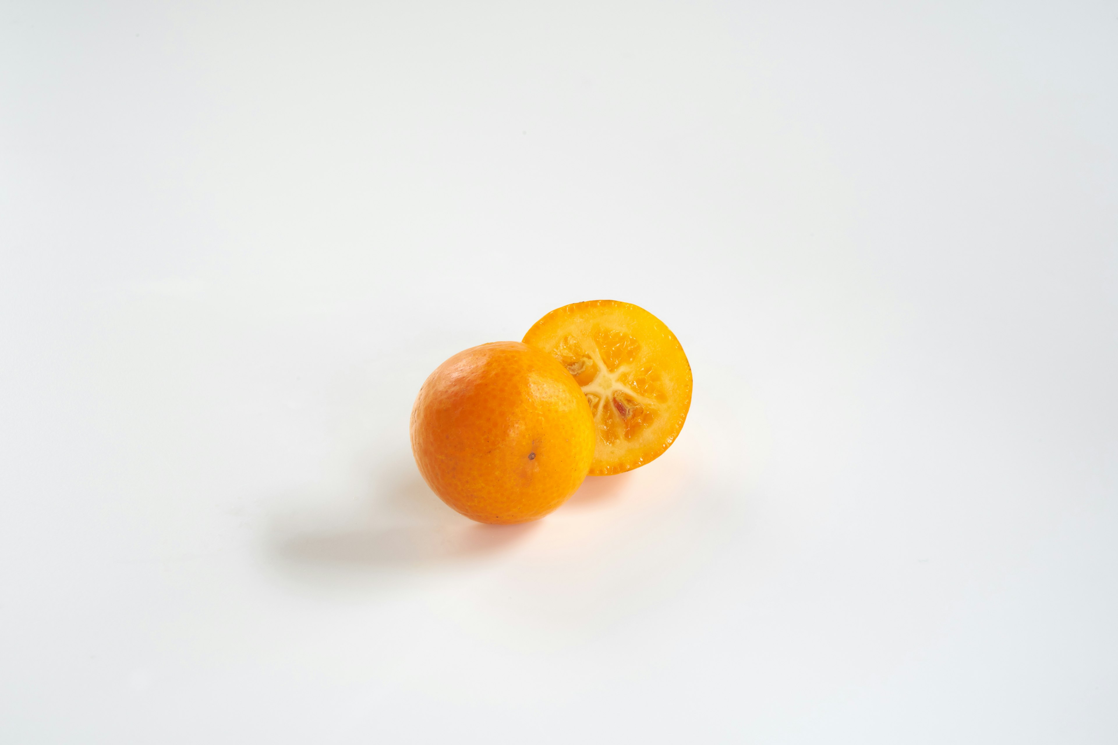 Fruta cítrica naranja cortada sobre fondo blanco