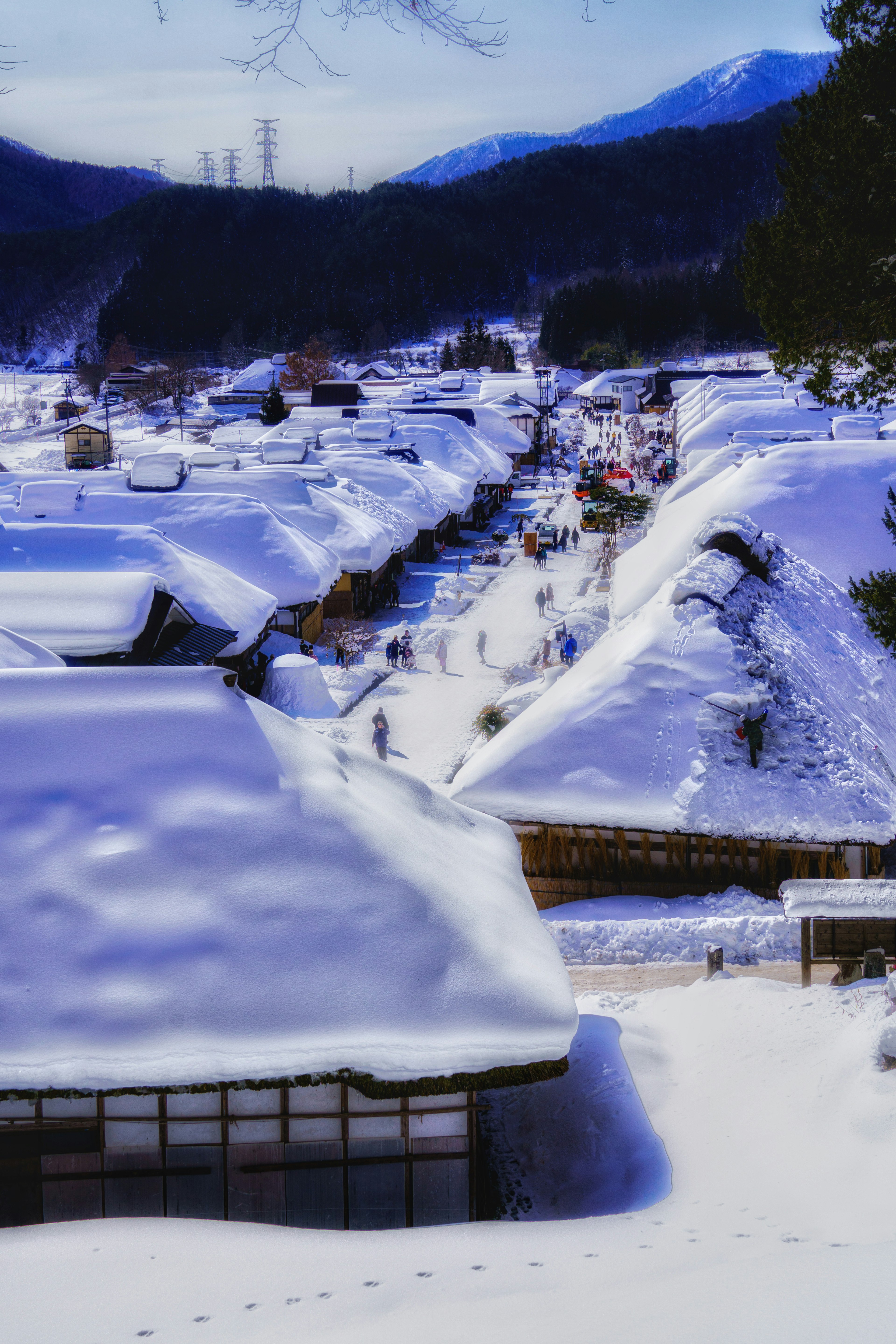 Snow-covered traditional Japanese village landscape with many people walking